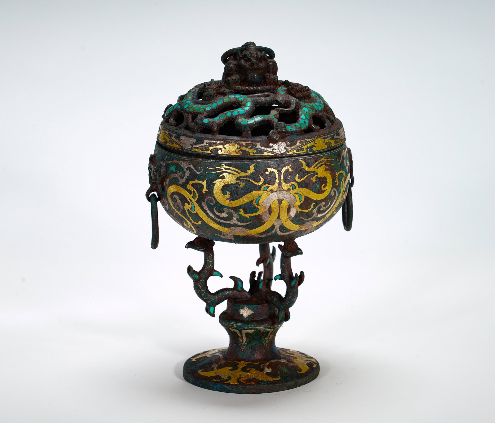 COPPER INLAID WITH GOLD AND SILVER AND TURQUOISE INCENSE BURNER FROM THE WARRING STATES PERIOD: Height:27cm (10.63in) Width:18cm (7.09in) Weight:2420g(5.34lb)Spherical incense burner supported by dragon-shaped feet. Openwork serpent lid with turquoise mosaic, interlaced golden dragon scrolls on 