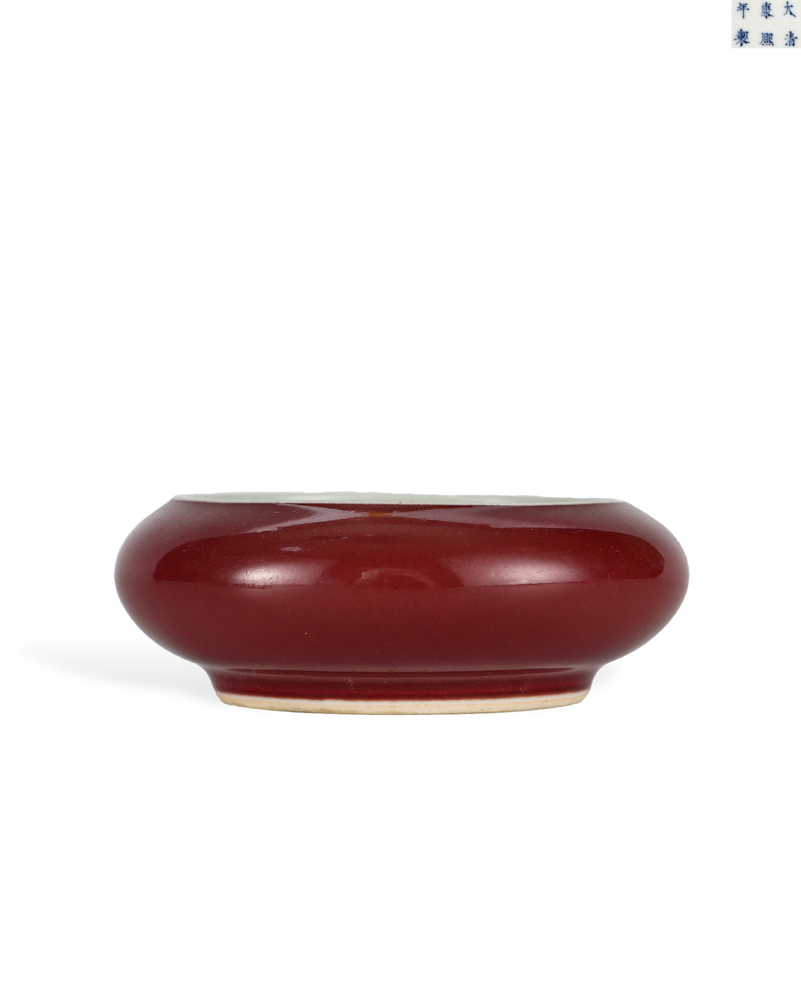 QING DYNASTY KANGXI LANG KILN RED GONG WASH: H:3.7cm W:10.7cm Official Qing Kangxi Langyao red glaze brush washer shaped like a gong, used for holding water for ink grinding. Flat rounded body with narrow mouth and shallow foot. The outer wall i