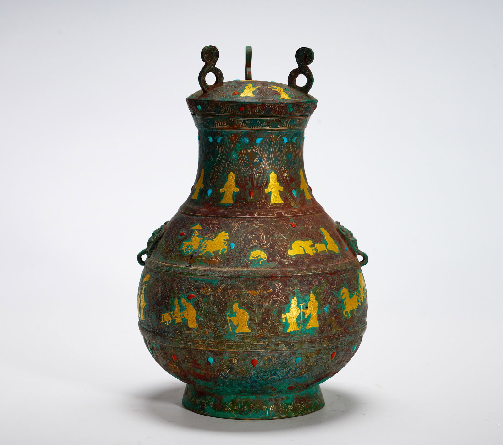 BRONZE POT OF THE WARRING STATES PERIOD WITH INLAID GOLD AND JEWELS AND PATTERNS OF PEOPLE TRAVELING: Height:30cm (11.81in) Width:20cm (7.87in) Weight:3980g(8.77lb)Bulbous bronze wine pot with lidded loop handle. Embossed human figures, carriage travel scenes in golden wire, colorful stone inlay. Hu s