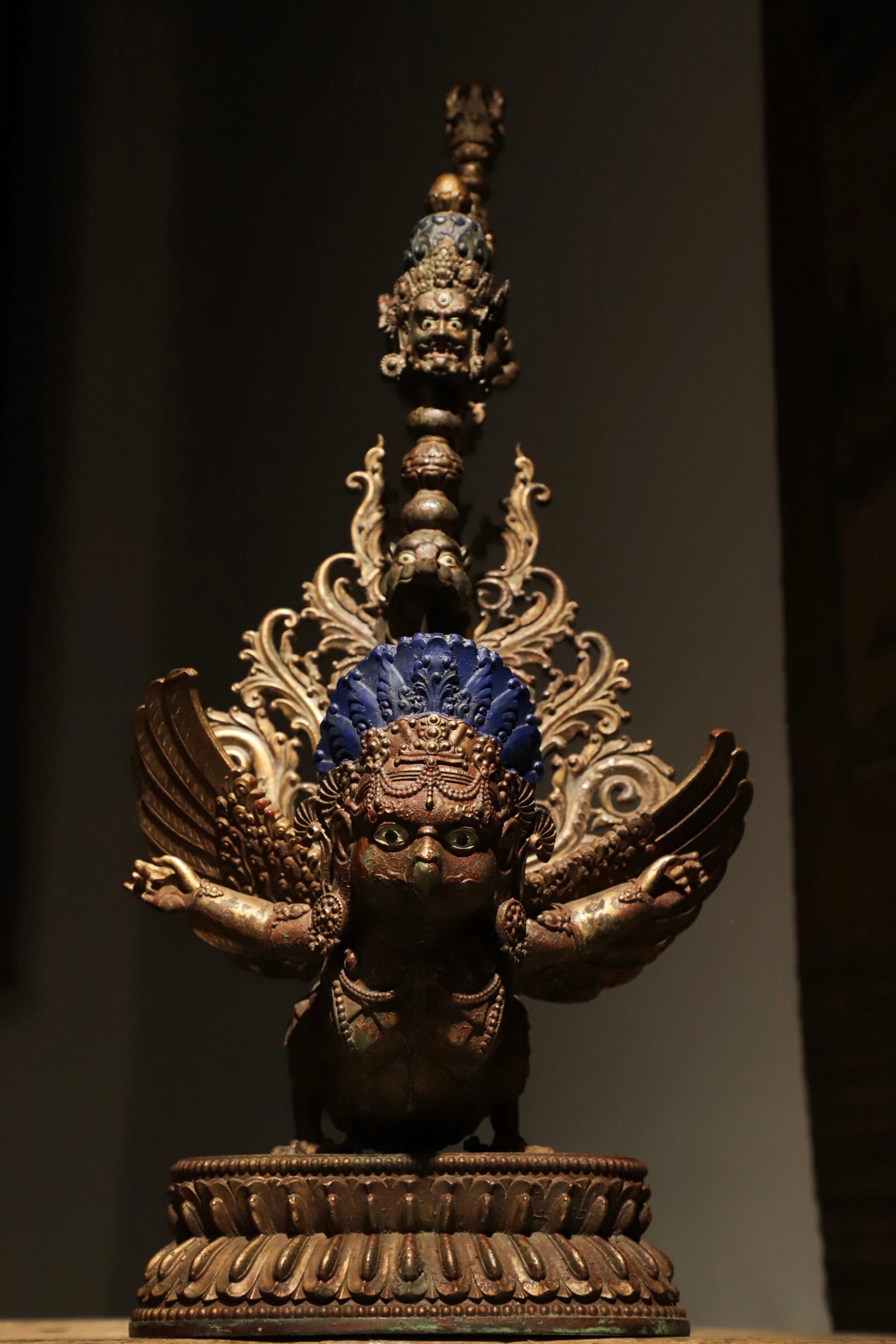 FINELY CAST BRONZE GILDED VAJRA STATUE OF THE GREAT PENG MINGWANG: H:60cm (23.62in) L:26cm (10.24in) W:20cm (7.87in) Weight:6750g (14.88lb)Fine bronze cast with partial gilding; centered on Garuda, the vajra shaft stacked with guardian heads and sacred birds topped w
