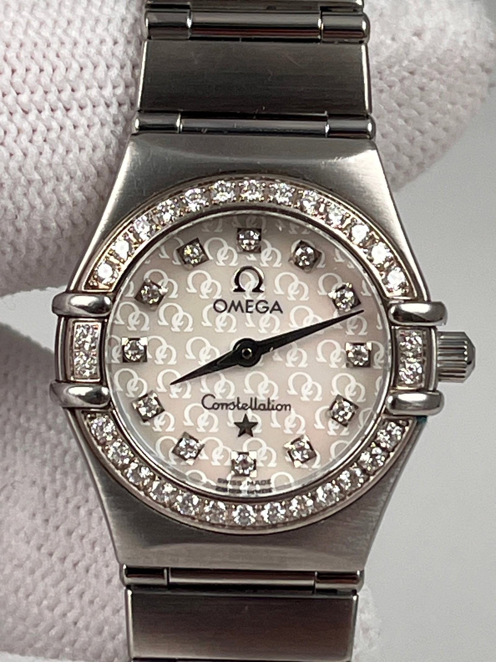 OMEGA LADIES' QUARTZ WATCH: 22mm stainless steel case with diamond-set bezel, mother-of-pearl dial with diamond hour markers, sapphire crystal glass, folding steel bracelet, solid case back, quartz movement