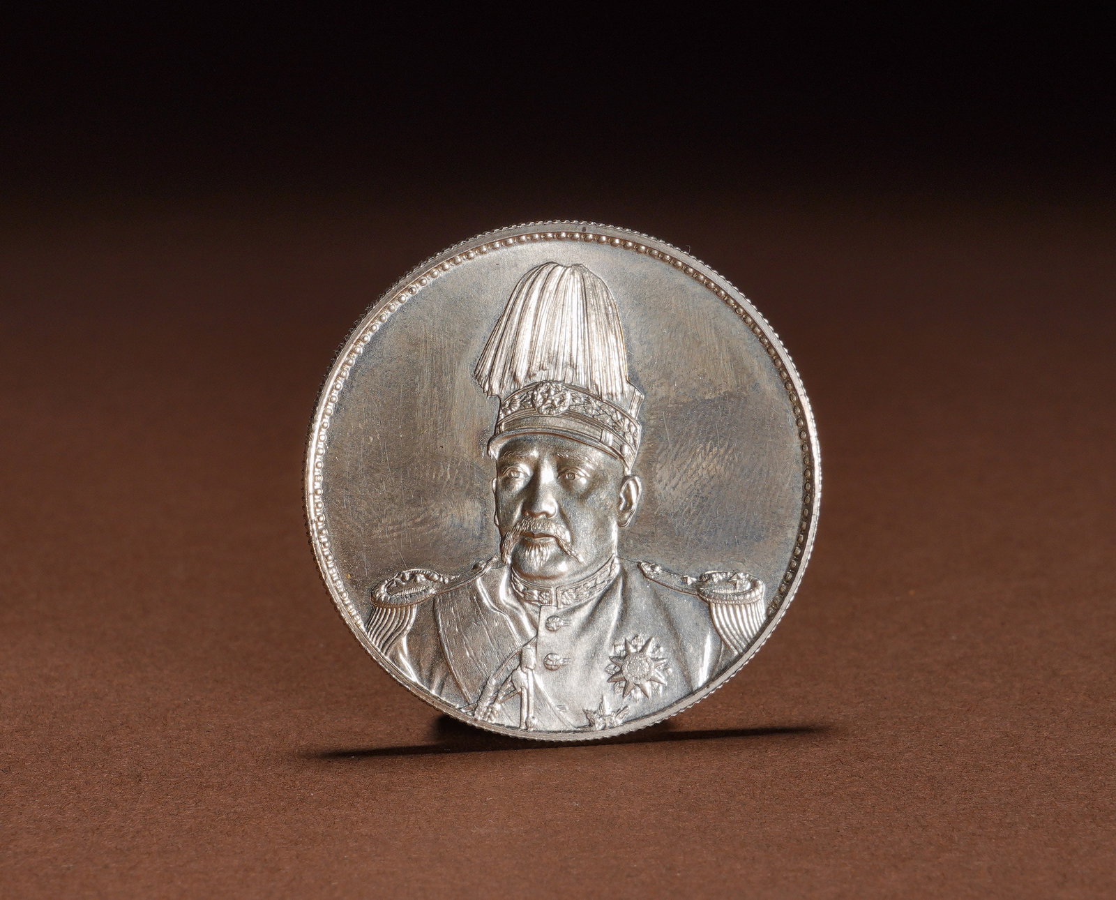 YUAN SHIKAI HONG XIAN ERA FLYING DRAGON UNSIGNED COMMEMORATIVE SILVER COIN: Diameter:3.9cmWeight:27gNon-signed Hongxian Era Flying Dragon commemorative silver dollar of Yuan Shikai, struck in silver with deep relief details. The obverse features a bust portrait of Yuan Shikai