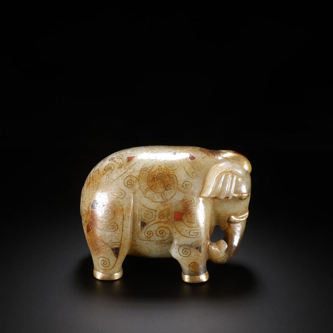 HAN HETIAN JADE INLAID WITH GOLD AND TREASURE ELEPHANT: Long:9.5cm(3.74in), Width:6cm(2.36in), Height:6.9cm(2.72in), Weight:686g (1.512lb)Archaic jade elephant ornament with gold threading and embedded gems. Carved from ancient jade covered with natural pa