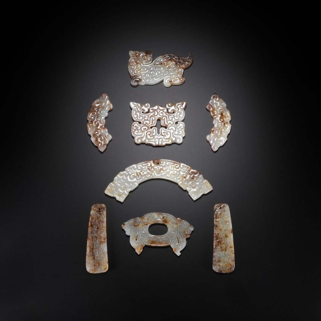 A SET OF HAN DYNASTY HETIAN JADE PENDANTS: Long:6.7cm(2.64in), Width:3.1cm(1.22in), Thick:0.5cm(0.20in), Weight:26g (0.057lb)Set of nine archaic jade pendants. Crafted from ancient jade with natural mottled patina. The suite consists of mythic