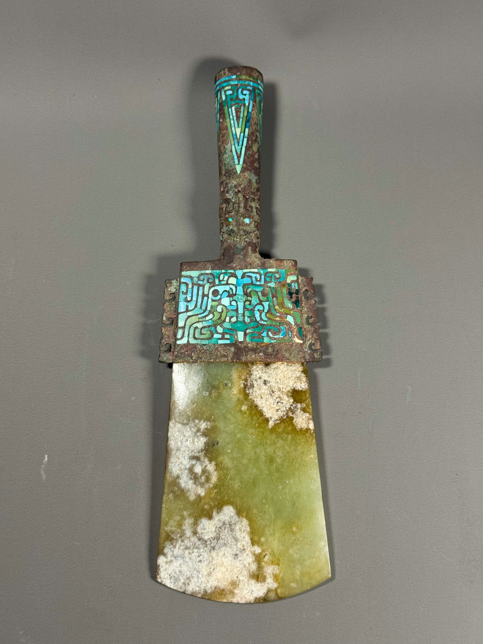 SHANG BRONZE INLAID WITH TURQUOISE AND JADE AXES: Height:8cmWidth: 25cmWeight:442gShang Dynasty, Jade Yue with Bronze Fitting Inlaid Turquoise.This ritual Yue is combined with bronze and celadon jade. The bronze handle and frame are inlaid with