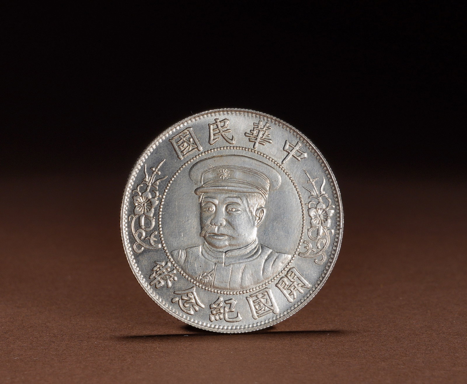 A COMMEMORATIVE SILVER COIN OF THE FOUNDING OF THE REPUBLIC OF CHINA BY LI YUAN-HONG: Diameter:3.9cmWeight:27gSilver commemorative coin of the Founding of the Republic of China featuring Li Yuanhong. Minted in silver, the obverse bears a bust portrait of Li Yuanhong in military cap enc
