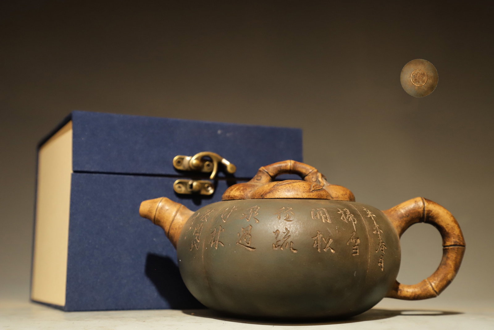 BAMBOO-JOINTED POETRY AND PROSE PURPLE CLAY TEAPOT: Long:19cm(7.48in), Height:8cm(3.15in), Width:12.5cm(4.92in)Crafted from purple clay. The teapot adopts melon shape, with spout, handle and lid modelled as bamboo joints. Calligraphy poems are carved