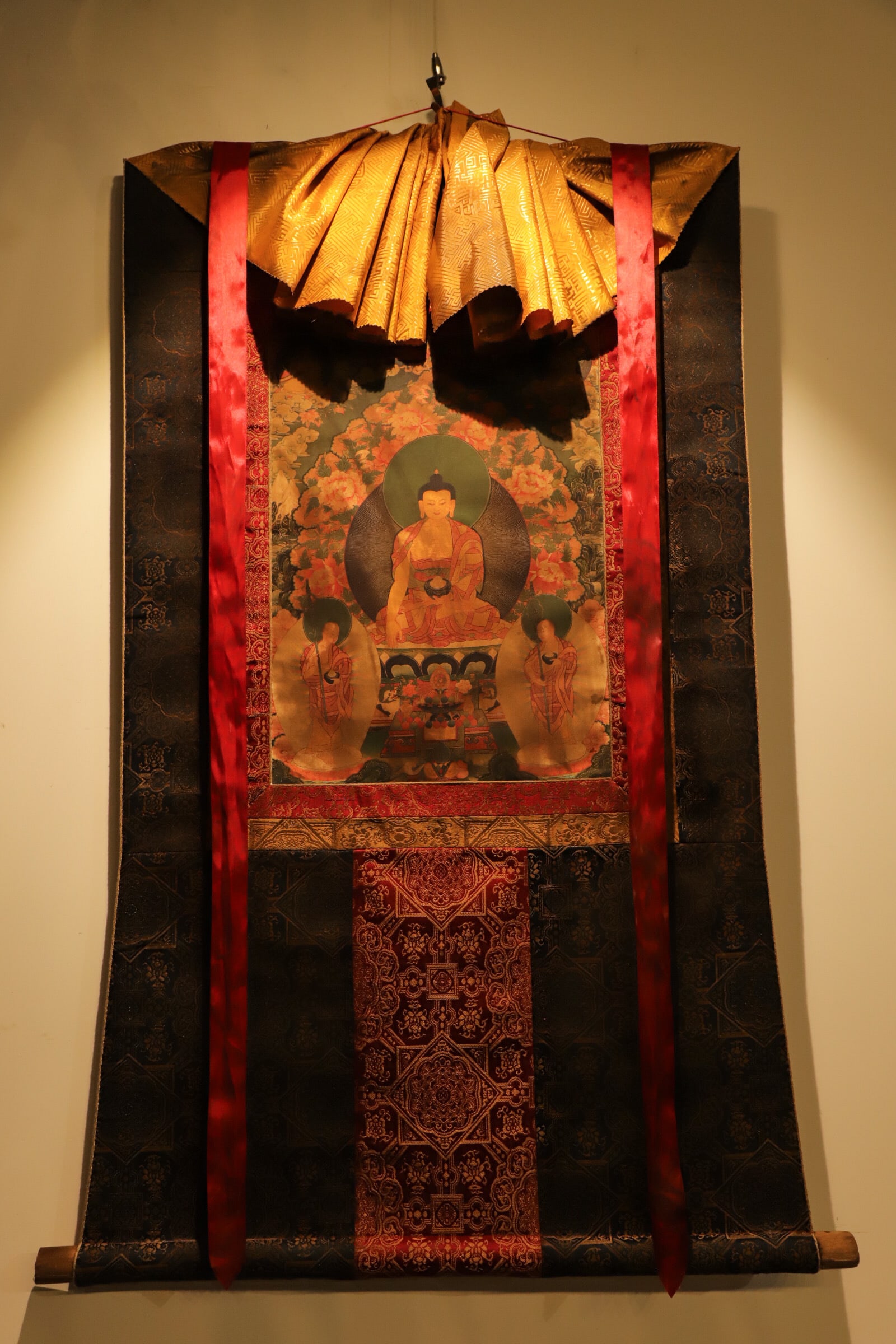 A THANGKA OF SAKYAMUNI IN TIBETAN BUDDHISM FROM THE QING DYNASTY: Height:110cm(43.31in), Long:75cm(29.53in)This fully mounted thangka is equipped with silk canopy, brocade border and wooden rollers. Shakyamuni Buddha sits in lotus posture with an alms bowl, flanked 