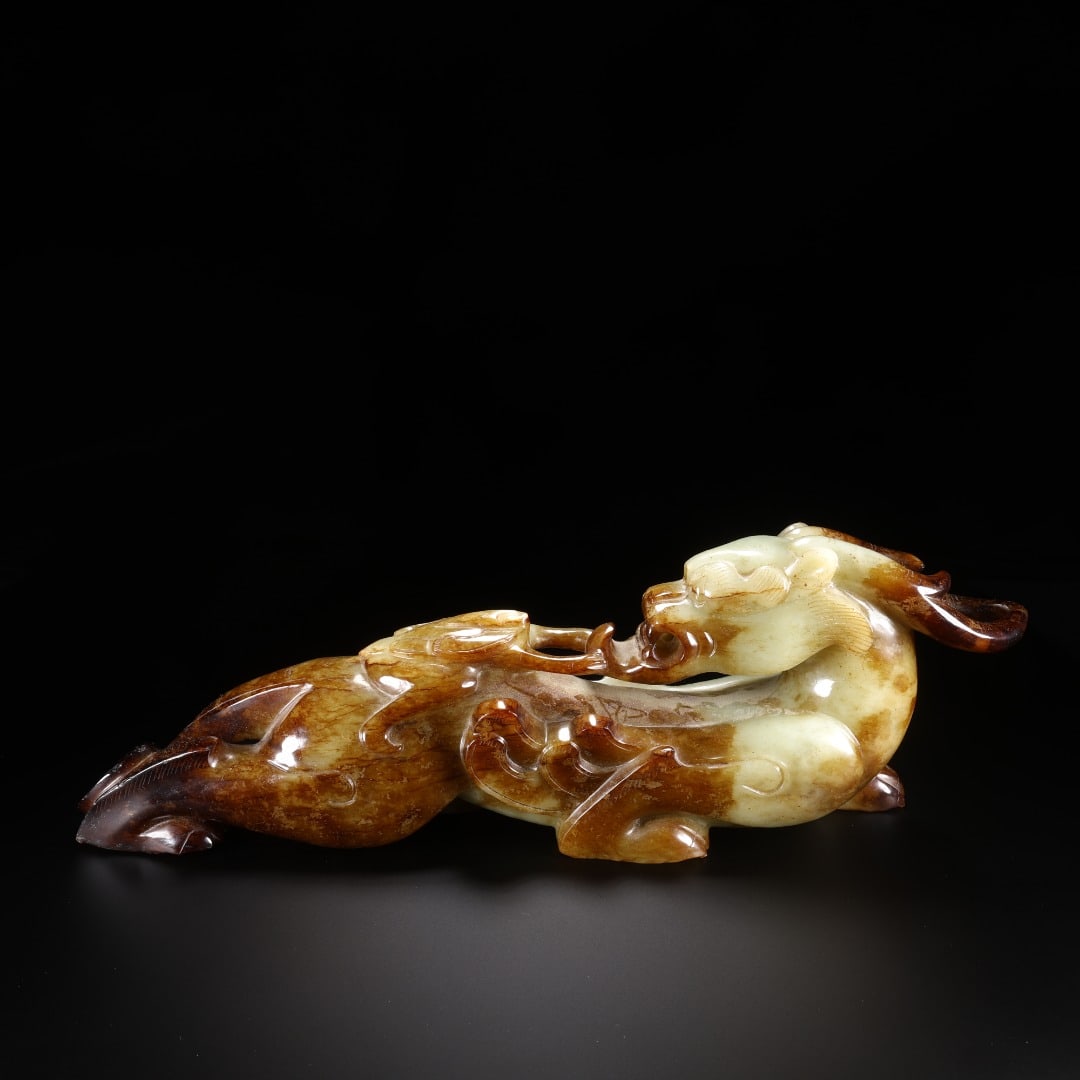 HAN HETIAN JADE HOOK-HEADED BEAST MASTER: Long:32.5cm(12.80in), Width:6cm(2.36in), Height:10.6cm(4.17in), Weight:2203g (4.857lb)Carved from mild Hetian white jade permeated with interwoven reddish-brown ancient patina. The crouching chi drago