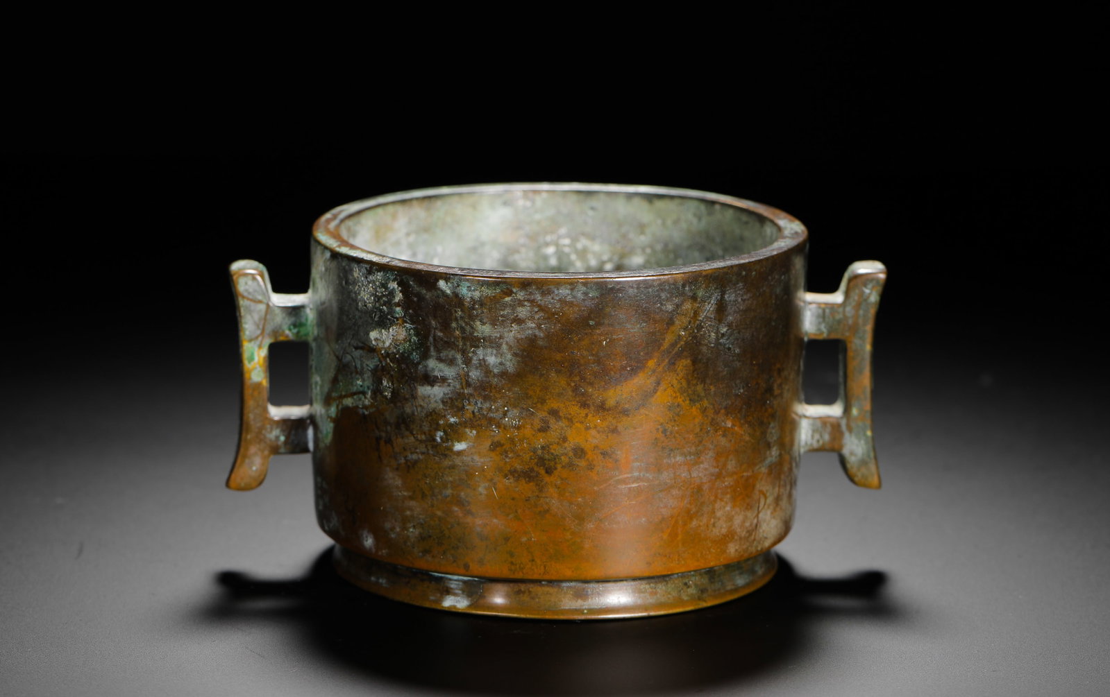 QING DYNASTY BRONZE HALBERD-EAR FURNACE: H:8cm (3.15in) W:10cm (3.94in) This is a Qing Dynasty bronze incense burner with a straight body and dagger-shaped handles on both sides. The base is inscribed with "Da Ming Xuande Nian Zhi",