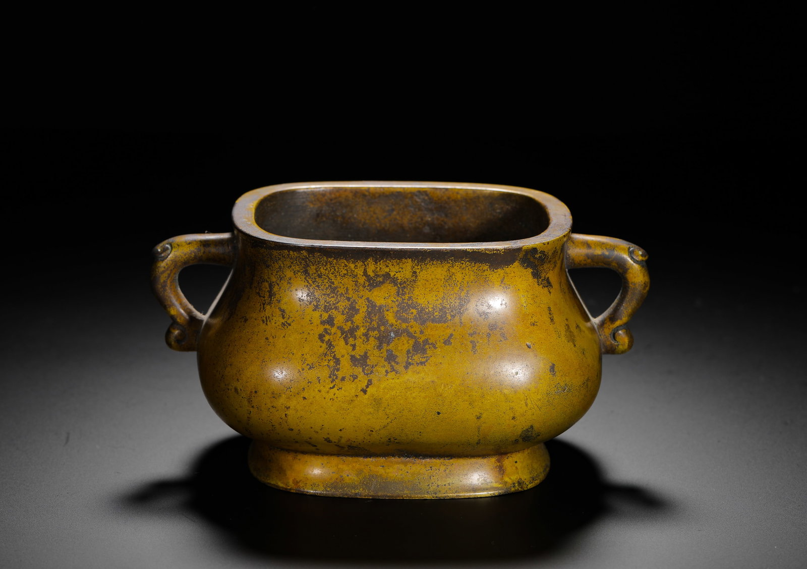 BRONZE ELEPHANT EAR FURNACE OF THE QING DYNASTY: H:7.5cm (2.95in) W:15cm (5.91in) Weight:1150g (2.54lb)This is a Qing Dynasty bronze incense burner with a square body and elephant-shaped handles on both sides. The base is inscribed with "Gushi" (anc