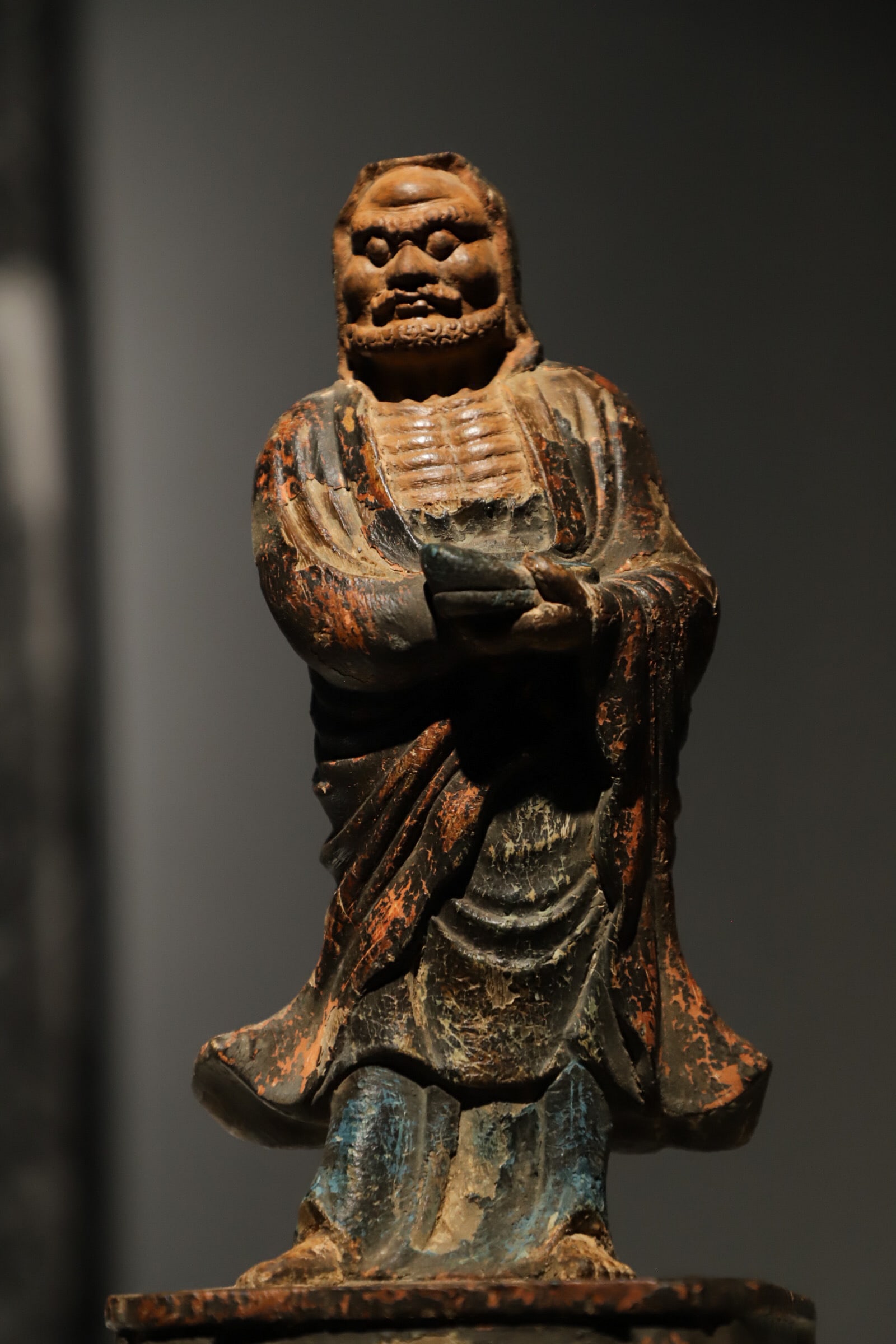 A STANDING STATUE OF BODHIDHARMA CARVED IN LACQUER AND GOLD FROM THE MING DYNASTY: Height:27cm(10.63in), Long:12cm(4.72in), Width:11cm(4.33in)Carved from single wood, Bodhidharma bears rugged facial features and full beard, with distinct bony ribs on chest. Draped in loose monk robe