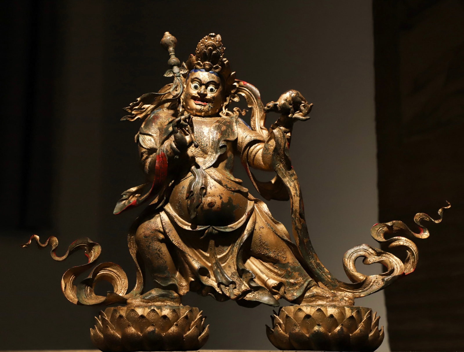 A GILDED BRONZE STATUE OF KING GESAR FROM THE QING DYNASTY: Weight:6250g (13.779lb), Height:32cm(12.60in), Long:42cm(16.54in), Width:11cm(4.33in)Cast in fine bronze with partial worn gilding, vermilion pigment preserved on lips. Wearing Tibetan heroic hat and 