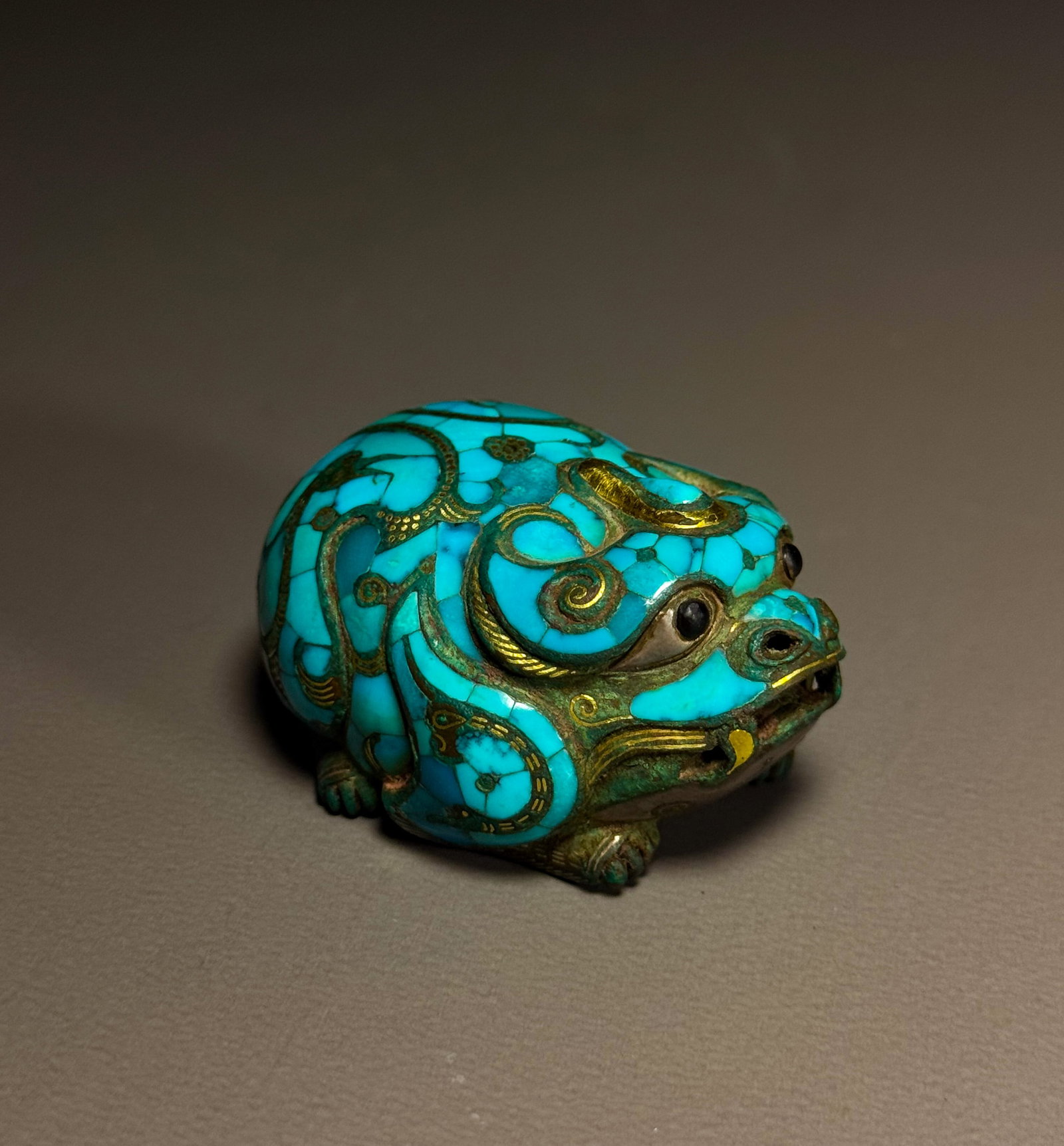 BRONZE WITH GOLD INLAID TURQUOISE BEAST TOWN FROM THE WARRING STATES PERIOD: Height:3cmWidth: 4.5cmWeight:120gWarring States Period, Bronze Mythical Beast Mat Weight with Gold Inlay and Turquoise Inlay.This bronze mat weight is shaped as a crouching mythical beast. The beast h