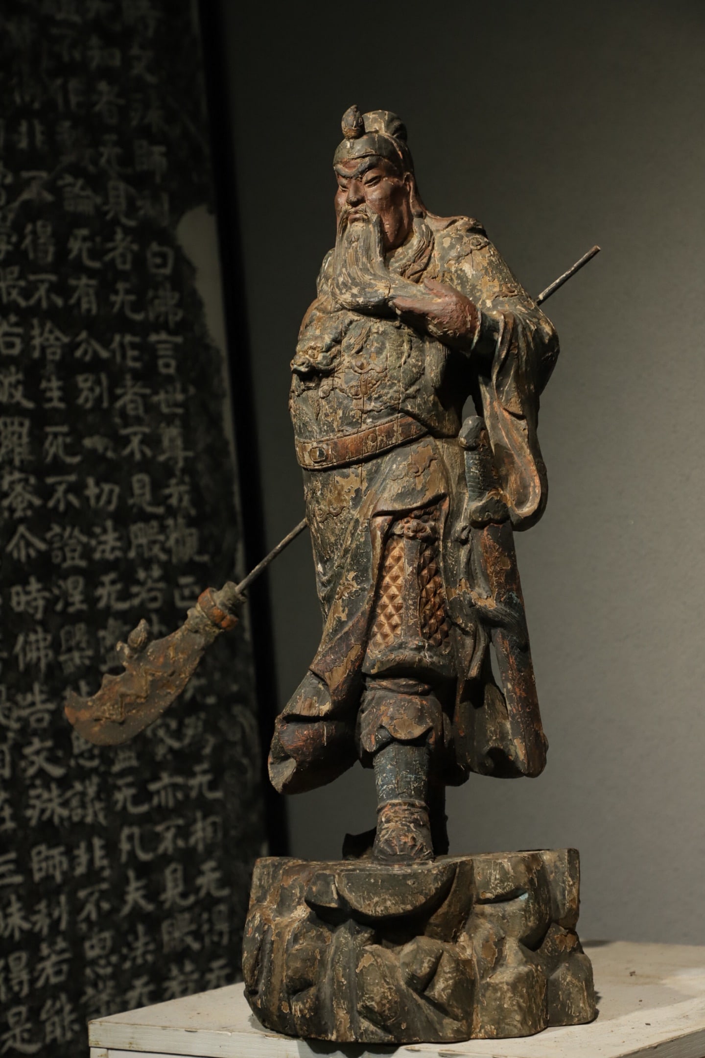 A STANDING WOODCARVING OF GUAN GONG FROM THE MING DYNASTY: Height:62cm(24.41in), Long:25cm(9.84in), Width:22cm(8.66in)This wooden standing statue of Guan Gong dates back to the Ming Dynasty, with worn lacquer and residual gilding preserved. The figure feature
