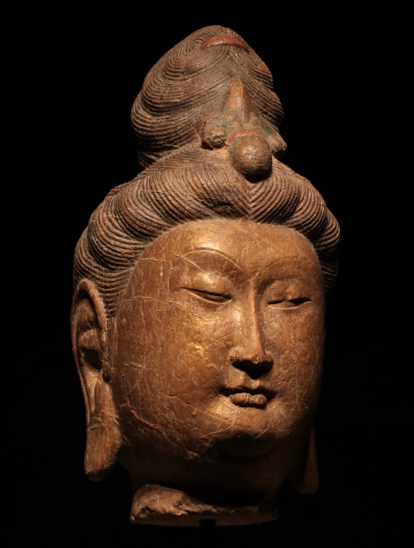 TANG DYNASTY WOODBLOCK GILDED GUANYIN HEAD: With base Height:68cm(26.77in)This gilt wood head of Guanyin Bodhisattva dates to the Tang Dynasty. Made of wood with gilded finish, its gold layer is mottled and worn, with natural craquelure on the 