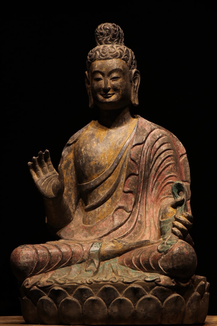 NORTHERN QI STONE-CARVED PAINTED SEATED STATUE OF SAKYAMUNI BUDDHA: Height:65cm(25.59in)This painted stone seated statue of Sakyamuni Buddha dates to the Northern Qi Dynasty. Carved from bluestone, its painted pigments are mottled and faded, with remaining traces of a