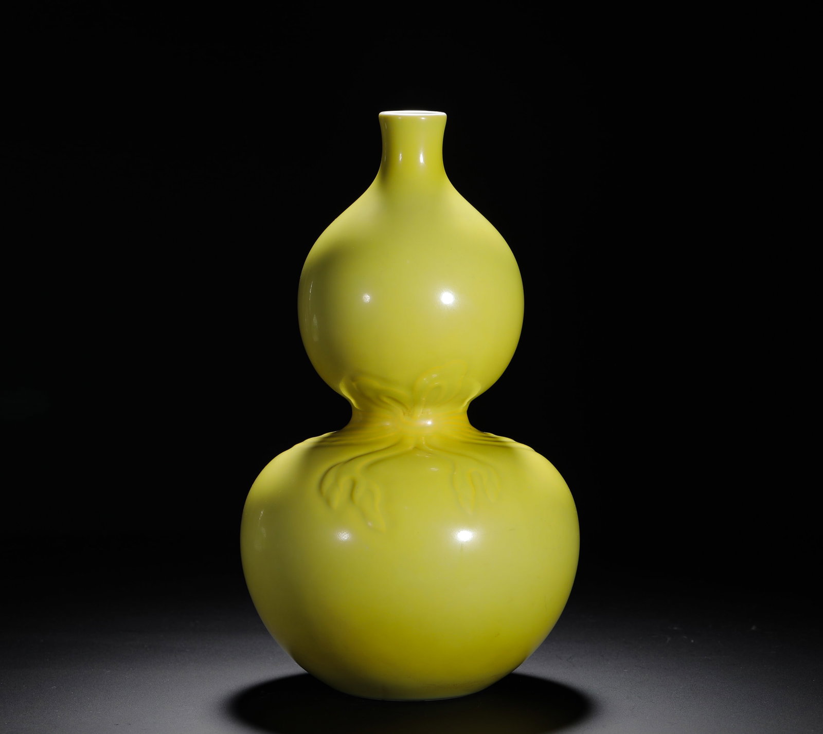 QING QIANLONG YELLOW GLAZED SASH GOURD VASE: H:27cm (10.63in) D:16cm (6.30in) Weight:1310g (2.89lb)This is an imperial porcelain vase from the Qianlong period, covered entirely in imperial yellow glaze with a carved ribbon motif, exemplifying th