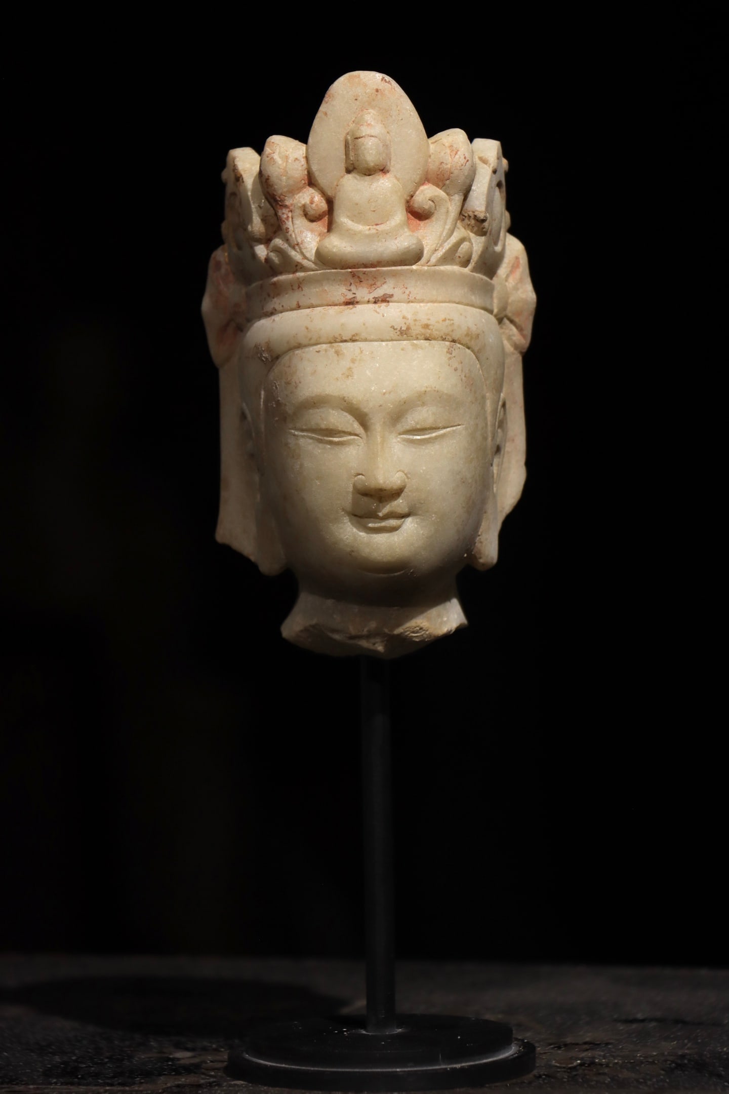 A WHITE MARBLE BUDDHA HEAD FROM THE NORTHERN QI DYNASTY: Dimensions without base Height:15cm (5.91in)White marble Guanyin Bodhisattva head, with small Buddha carved on the central scroll crown, residual red mineral pigment decoration, Chinese traditional st