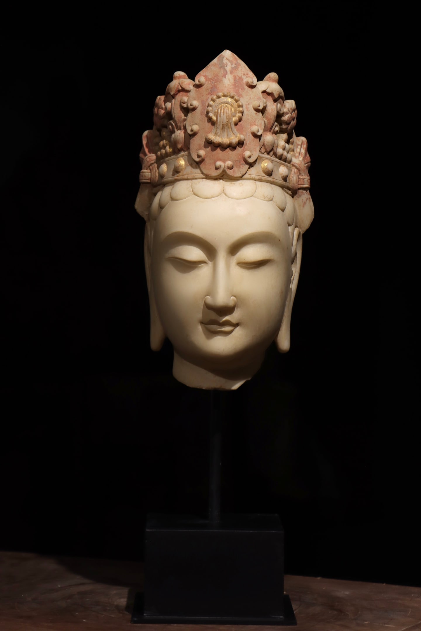 THE HEAD OF THE BODHISATTVA GUANYIN PAINTED ON WHITE MARBLE FROM THE SUI DYNASTY: Height:29cm(11.42in),Height:49cm(19.29in)Antique Sui-Tang white marble Avalokiteshvara head, faded gold and red pigment, relic of grotto-style statue embodying mercy and blessing.