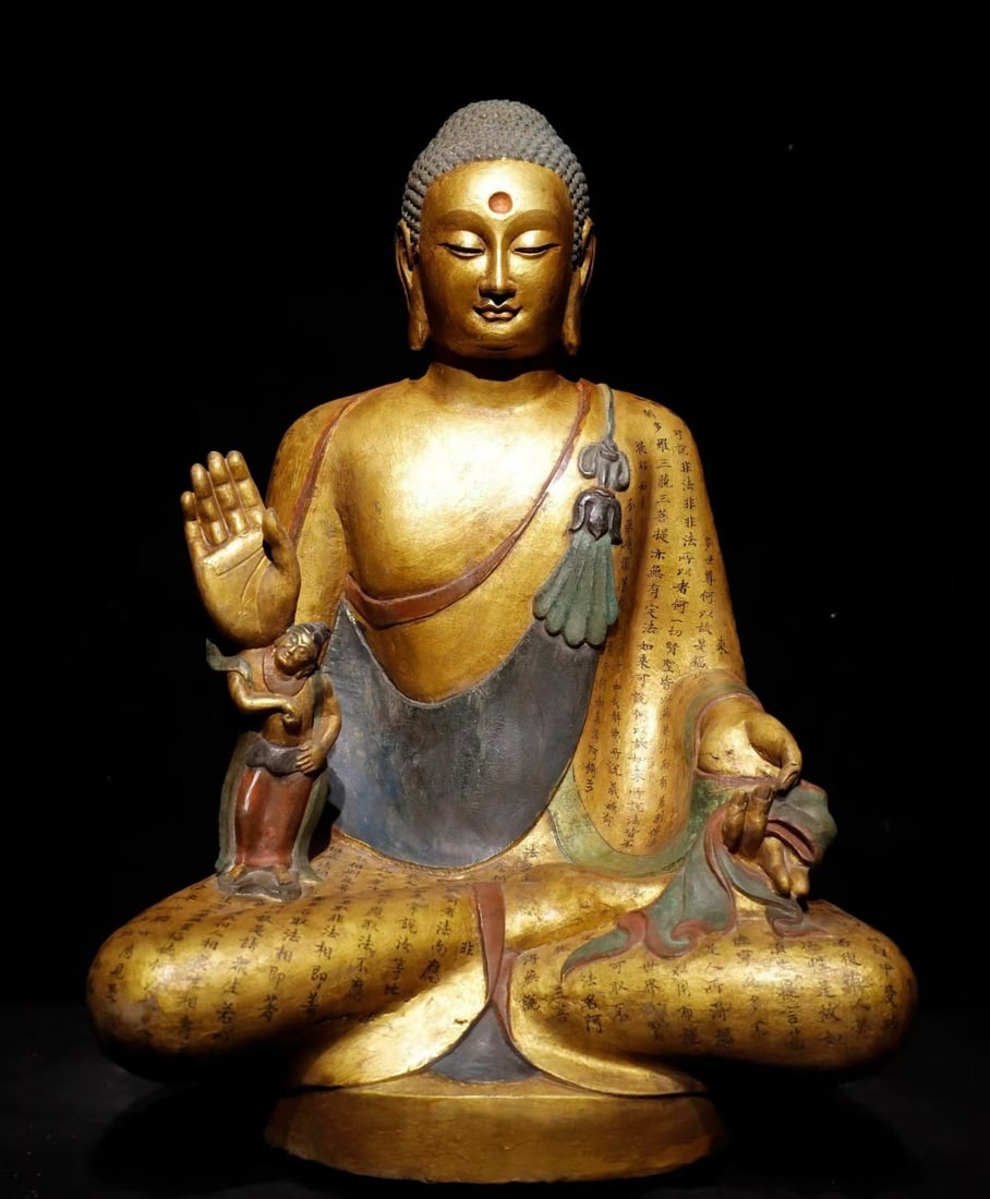 TANG DYNASTY STONE-CARVED, PAINTED AND GILDED SCRIPTURE SEATED STATUE OF SAKYAMUNI: Height:68cm(26.77in), Width:48cm(18.90in), Thick:35cm(13.78in)Stone Buddha statue with painted decoration and gilding. Shakyamuni sits in full lotus posture, right hand forming Abhaya mudra. Tight spi