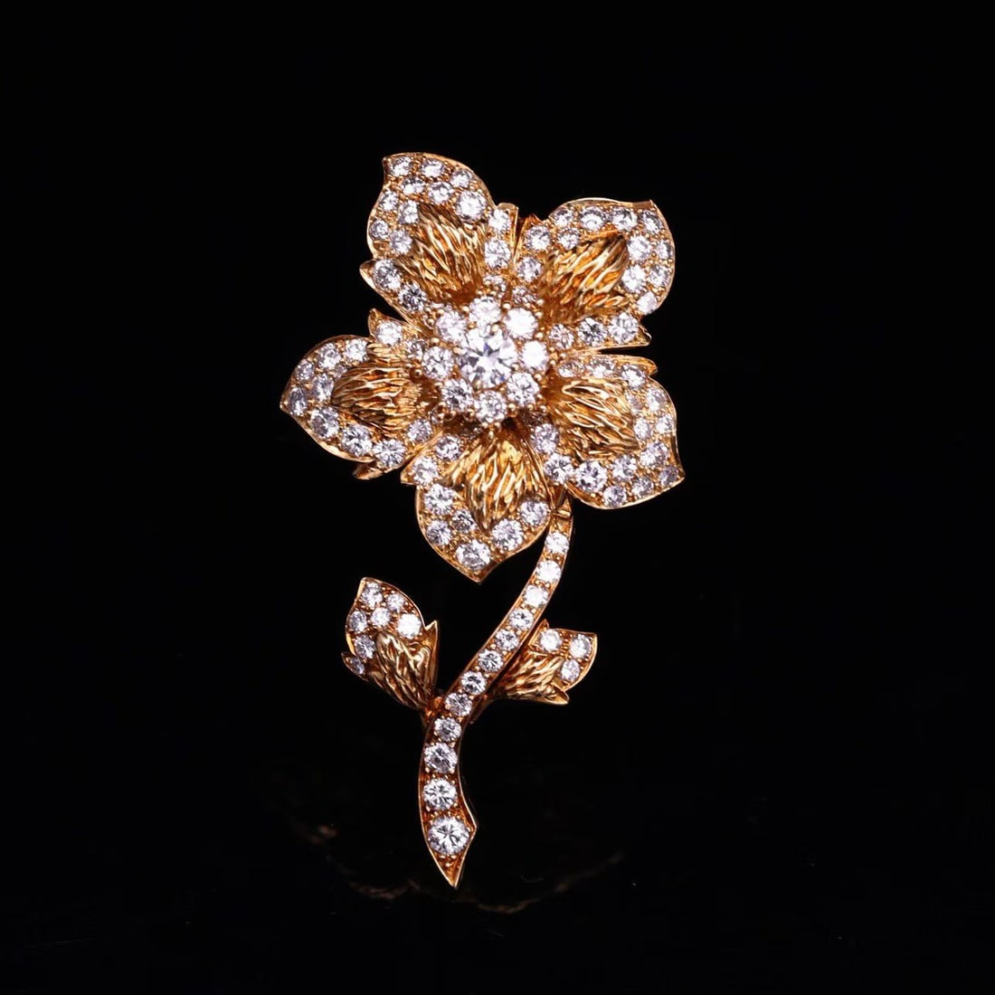 VAN CLEEF & ARPELS DIAMOND FLORAL BROOCH: The brushed texture of gold contrasts with the brilliance of diamonds, reflecting Van ClevelandArpels' precise capture of natural forms and fine jewelry craftsmanship. Weight 19.3 g dimensions 60X33 m