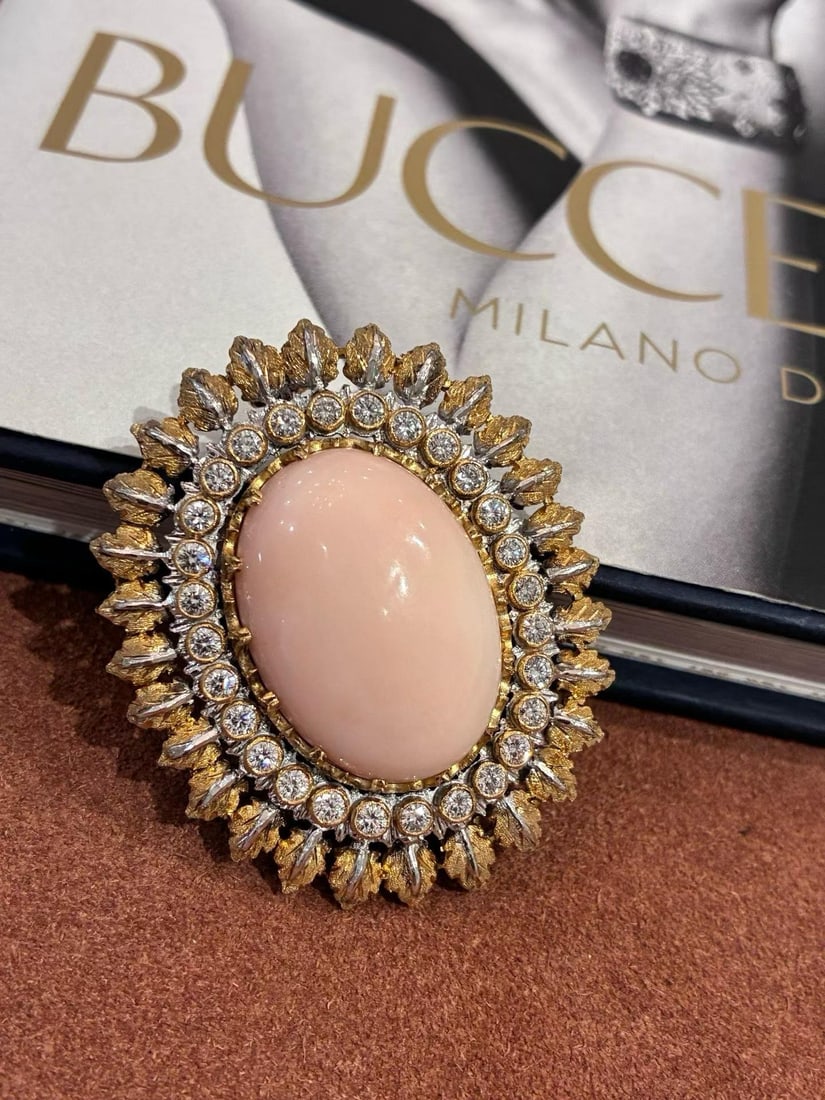 18K GOLD FEDERICO BUCCELLATI PINK CORAL BROOCH: Entirely hand-chiseled with intricate woven leaf patterns, each leaf's texture is meticulously hammered by the artisan one strike at a time. The contrast between gold and silver creates rich, layered