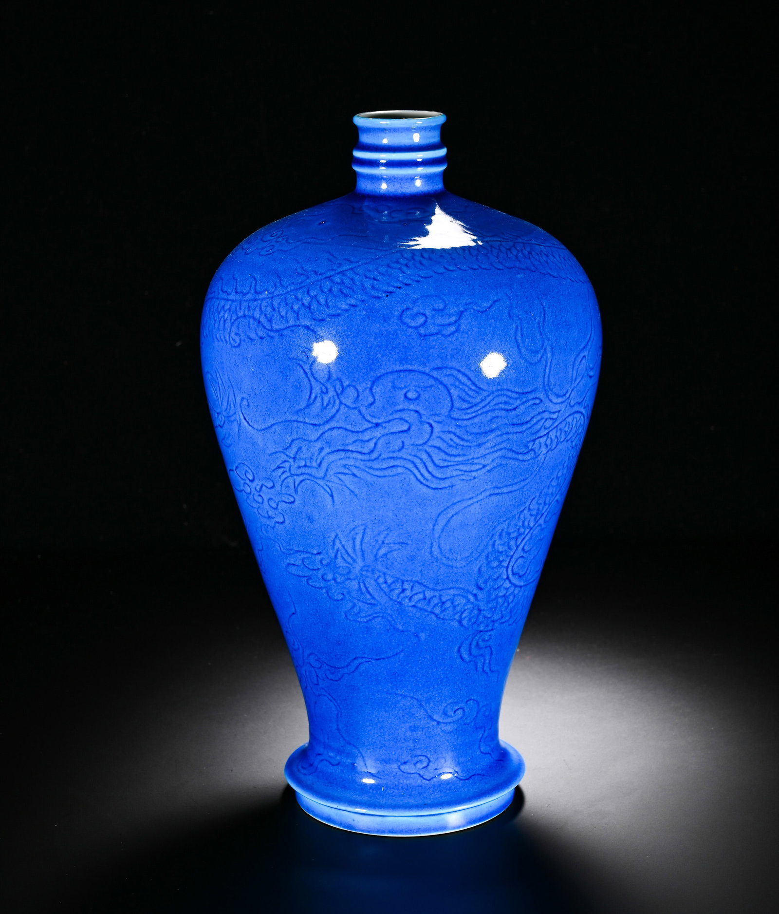 A QING DYNASTY QIANLONG PEACOCK BLUE GLAZED VASE WITH DARK ENGRAVED CLOUD AND DRAGON PATTERNS: Height:32cm (12.60in) , Diameter:15cm (5.91in) Imperial?quality meiping vase of Qianlong reign, with small ribbed mouth, broad shoulders and tapering lower body, presenting stately silhouette. The who