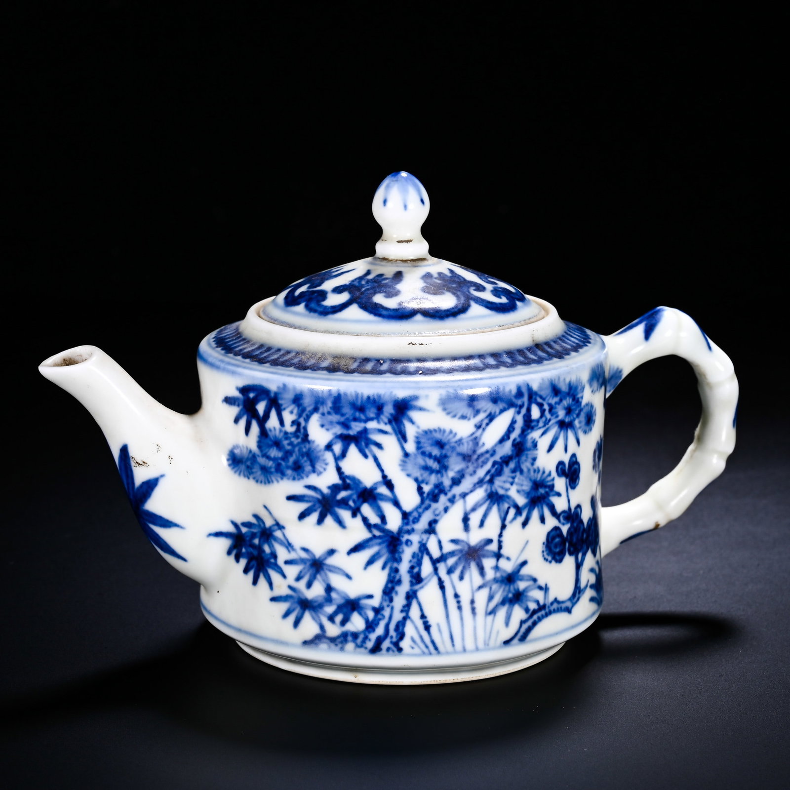 MING CHENGHUA BLUE AND WHITE WINTER THREE FRIENDS BAMBOO JOINT TEAPOT: Height:10cm (3.94in) , Width:15cm (5.91in) Cylindrical?bodied teapot with curved spout, bamboo?joint?shaped handle and bead?knob cover. The exterior is painted with pine, bamboo and plum?blossom, the 