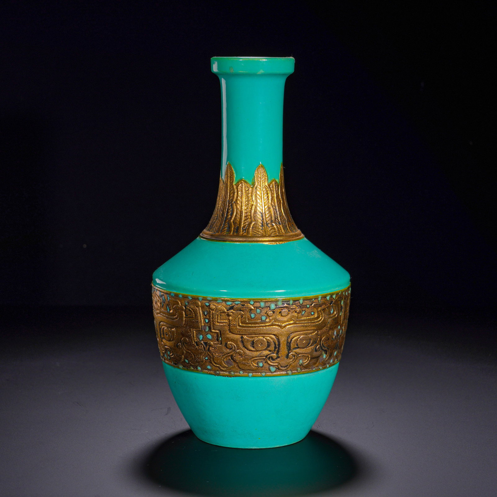 QING QIANLONG TURQUOISE GREEN GLAZE GILDED BRONZE ANIMAL FACE PATTERN STRAIGHT-NECKED BOTTLE: Height:23cm (9.06in) , Diameter:12cm (4.72in) Vase with flared mouth, slender straight neck, angular shoulder, rounded body and ring foot, of stately silhouette. The whole body is covered with smooth,