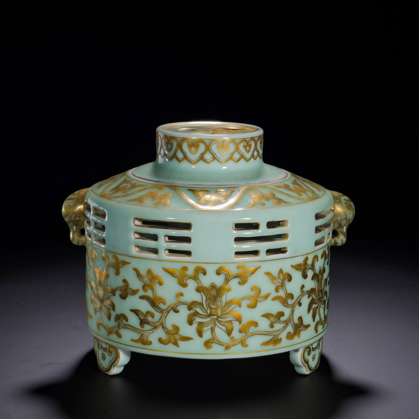 A THREE-LEGGED INCENSE BURNER WITH GILDED AND COILED FLORAL AND ANIMAL-EAR PATTERNS IN THE QIANLONG: Height:17cm (6.69in) , Diameter:22cm (8.66in) An imperial?quality incense burner composed of lid and body. The vessel is covered in soft even dou?qing celadon glaze. The lid features bagua?pattern ope