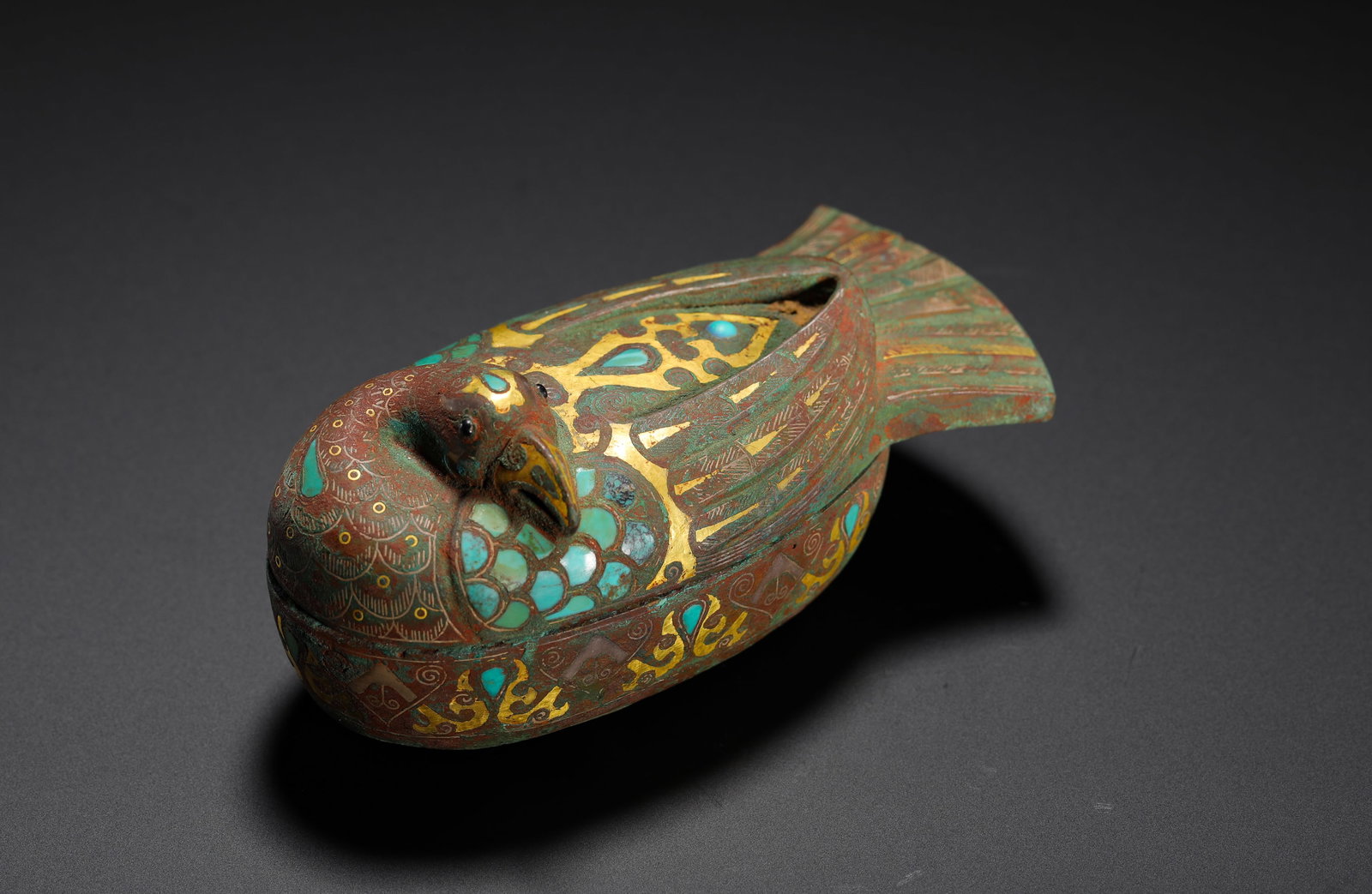 A HAN DYNASTY INLAID GOLD AND SILVER WITH TURQUOISE AND BIRD-SHAPED INCENSE BOX: H:4cm (1.57in) W:10cm (3.94in) Weight:180g (0.40lb) Dove-shaped lidded bronze censer, gold-silver feather scrolls, turquoise mosaic inlay, hollow interior for incense storage.