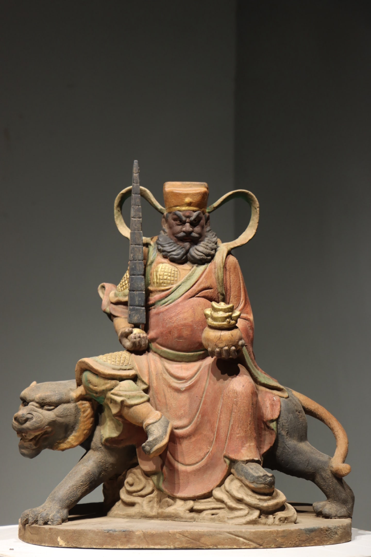 MING DYNASTY WOODCARVING GOD OF WEALTH - ZHAO GONGMING: H:57cm (22.44in) W:53cm (20.87in) T:30cm (11.81in) This God of Wealth Zhao Gongming statue sits solemnly on a fierce tiger mount, resting on a cloud-pattern pedestal. It features majestic stern facial