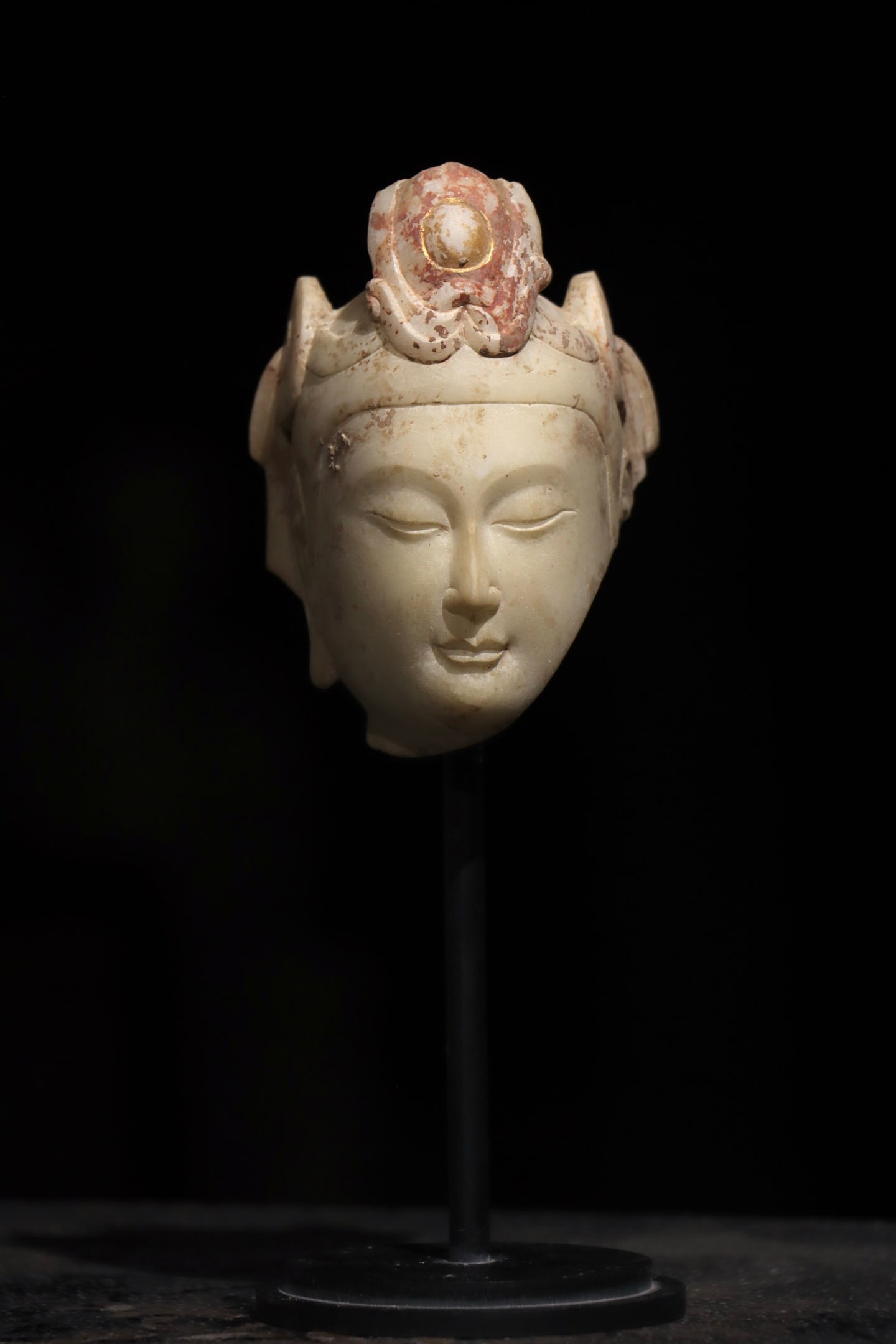 A WHITE MARBLE GUANYIN HEAD FROM THE NORTHERN QI PERIOD: Dimensions without base Height:11cm (4.33in) White marble Guanyin Bodhisattva head with residual gilded and red mineral pigment decoration, Chinese traditional stone Buddhist sculpture
