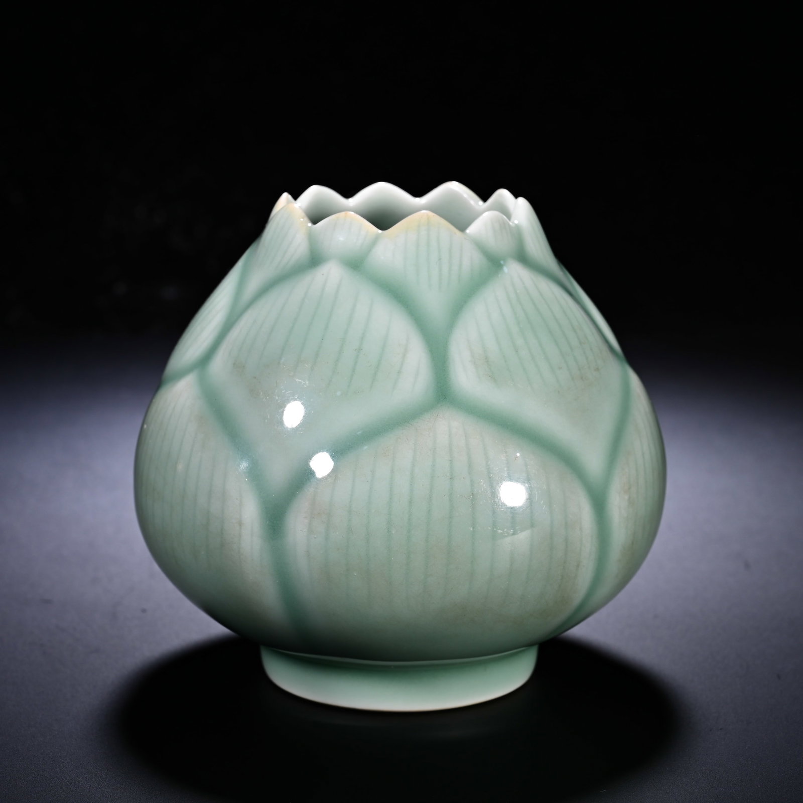 QING DYNASTY QIANLONG BEAN GREEN GLAZED IMITATION LOTUS-SHAPED WATER BOWL: Height:9cm (3.54in) , Diameter:9cm (3.54in) A fine example of Qing?dynasty biomorphic porcelain. Modelled in the shape of a budding lotus flower, the body is moulded in relief with overlapping lotus p