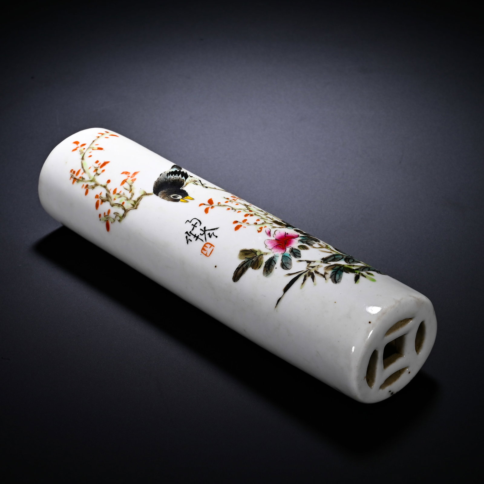 LIGHT CRIMSON FLOWER-AND-BIRD PATTERNED PORCELAIN PAPERWEIGHT OF THE REPUBLIC OF CHINA ERA: Height:16cm (6.30in) , Diameter:4.5cm (1.77in) Elongated cylindrical scholar??s paper?weight with coin?pattern openwork at one end. The body is decorated in qiangjiang?cai palette: a bird perches on b