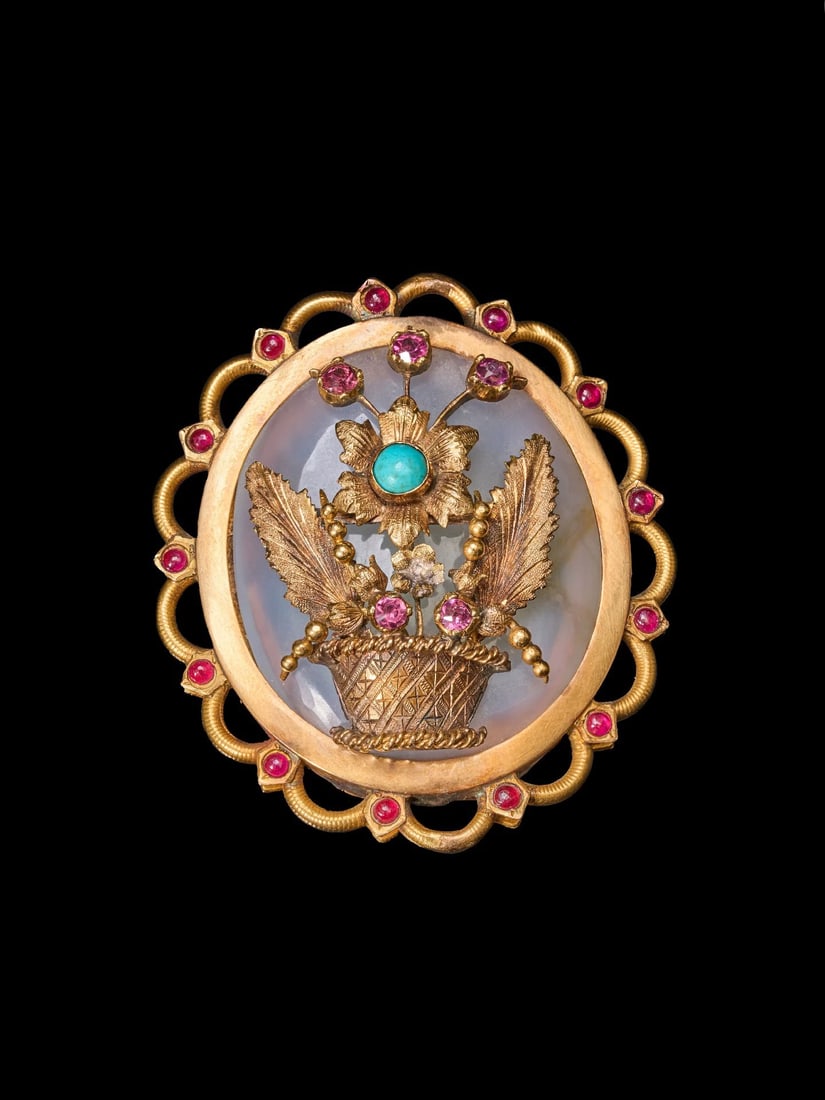 Late 19th / Early 20th Century European 18K Ruby and Turquoise Basket Brooch: 4.8*4.2cmWt:21.7g The brooch is built upon a mother-of-pearl base, with a flower basket mounted atop it. The translucent mother-of-pearl delivers distinct layers and strong three-dimensionality. The b