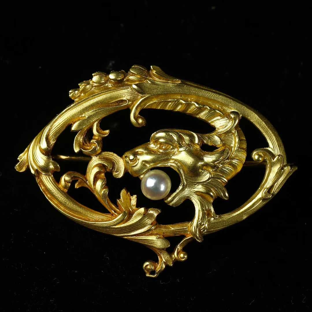 Art Nouveau (1880-1920) French Antique Chimera Dragon Brooch with Natural Pearls in 18K Gold: L:3.9cm W:2.6cm Wt:7.4g Handcrafted entirely in 18K gold, featuring a double-sided chased chimera dragon motif. Flowing lines convey powerful bodily tension. The creature holds a wild seawater pearl i