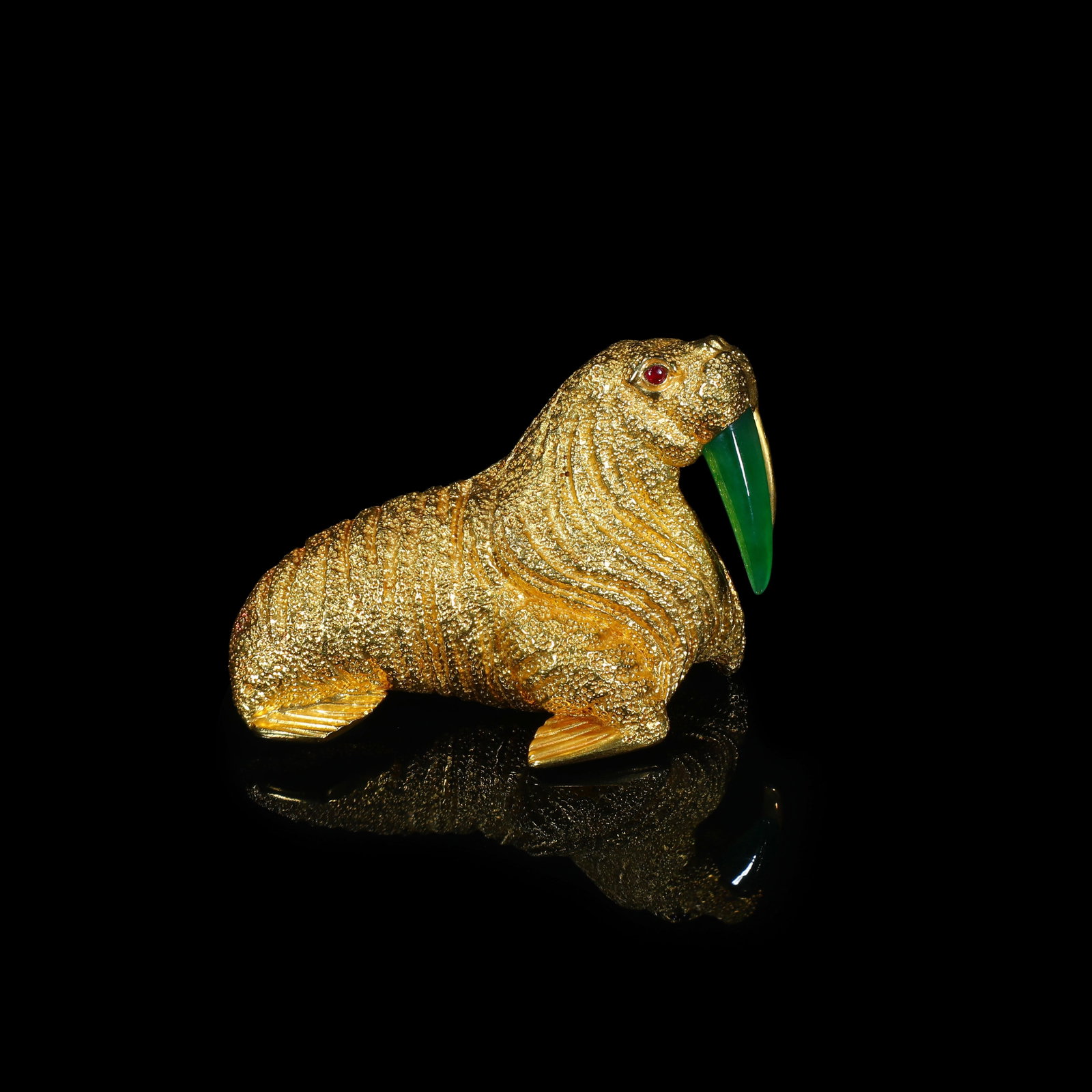 Mid-20th-Century 18-Carat Gold Walrus Brooch, with Jade Tusks and Ruby-Set Eyes: 4.4*6.1cm Wt:34.22g Mid-20th-century animal-motif antique brooch modelled as a walrus in 18-carat gold. The gold surface is finished with granular textured work to faithfully render the wrinkled skin 