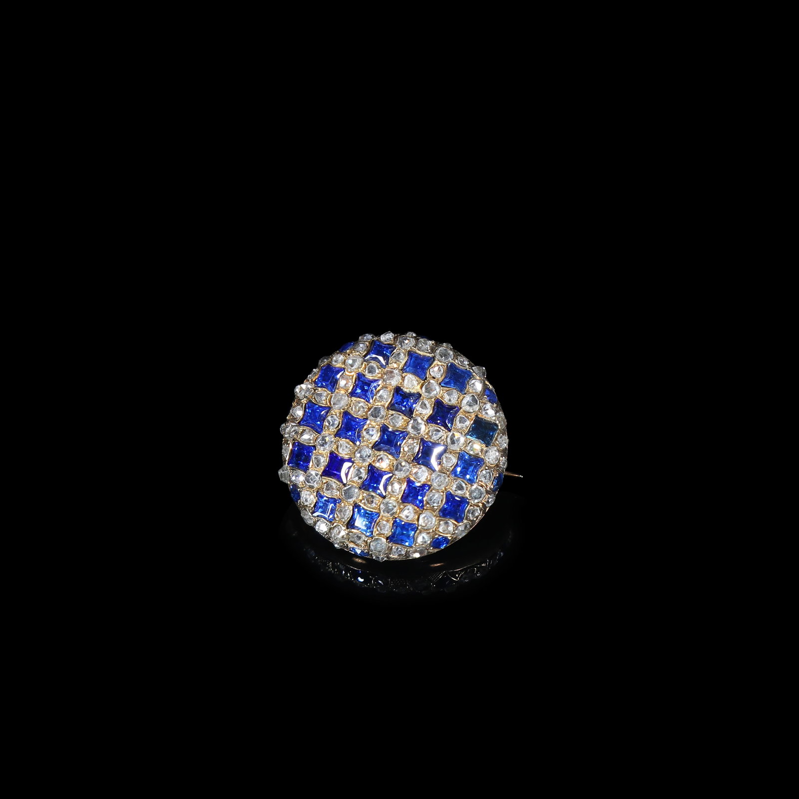 Victorian-Era (Circa 1860-1880) Gold Sapphire & Old-Cut-Diamond Checkerboard Circular Brooch: D:2.26cm Wt:8.1g Victorian-era (circa 1860-1880) circular brooch in precious-metal mount. The surface set in checkerboard pattern, square-cut sapphires alternating with old-cut diamonds forming regula