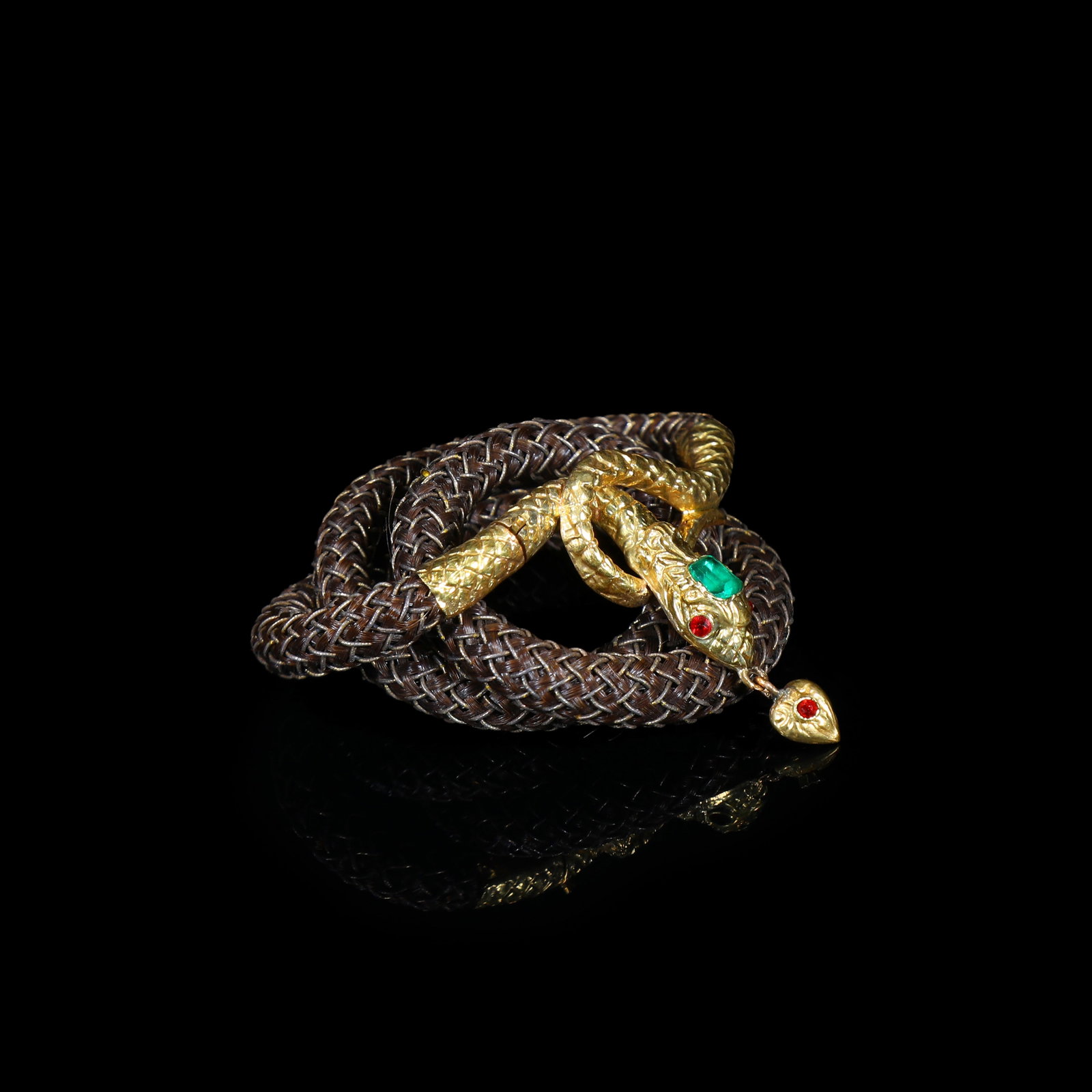 Victorian 19th-Century 18K-Gold Serpent Memorial Jewellery with Emerald, Rubies and Human-Hair-Work: Bracelet Length:14.5cm Wt:8.48g Victorian memorial jewellery, 19th century. The chain is woven from human hair, fitted with a cast 18-carat-gold serpent-form mount. The serpent's head is centred by a 
