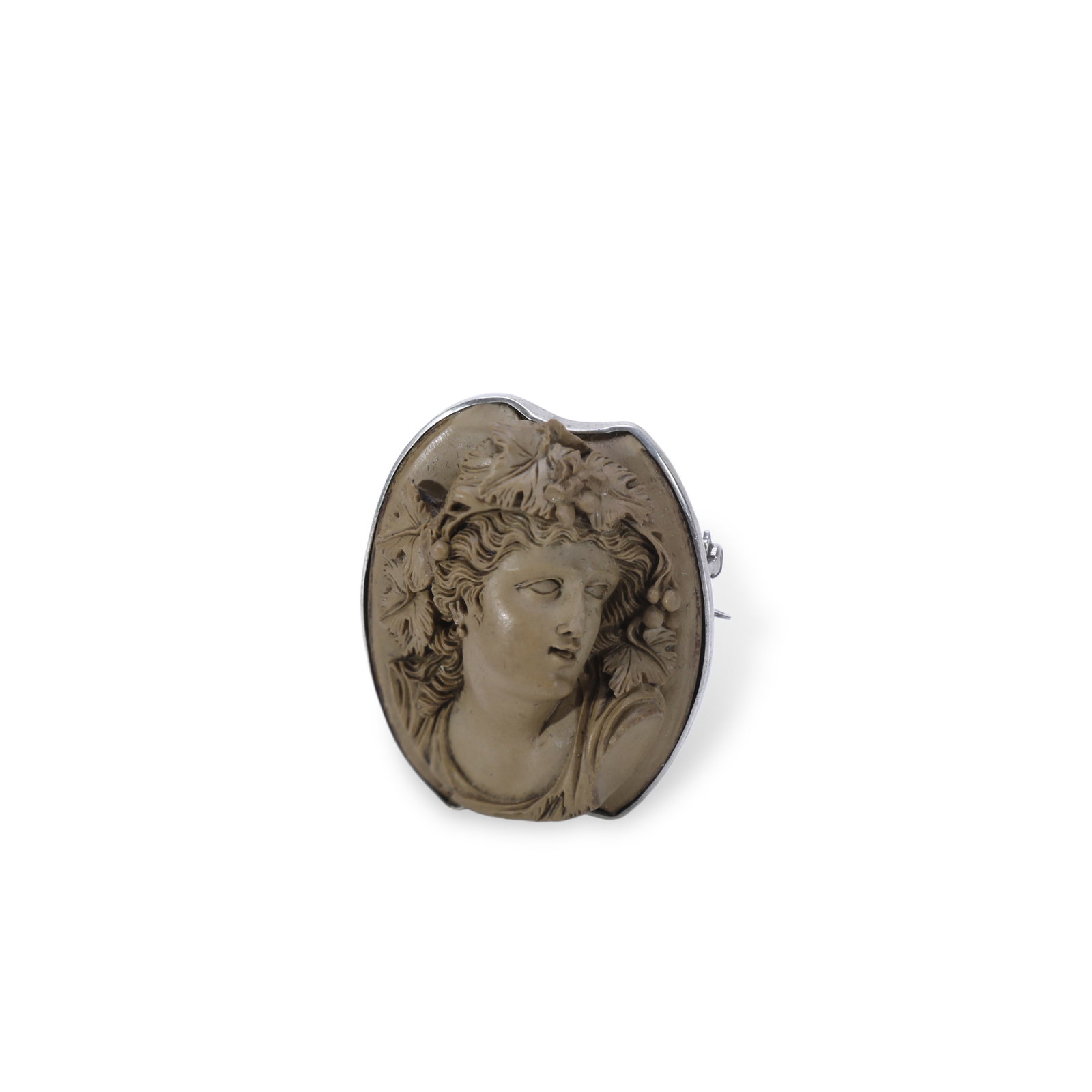 Victorian Italian Silver-Mounted Volcanic Stone Cameo Brooch Depicting Bacchus: H:4.2cm W:3.5cm The piece centers on the mythological figure Bacchus, God of Wine. The relief-carved figure wears a crown woven with grape leaves and fruit, rendered with elegant archaic lines embodyi