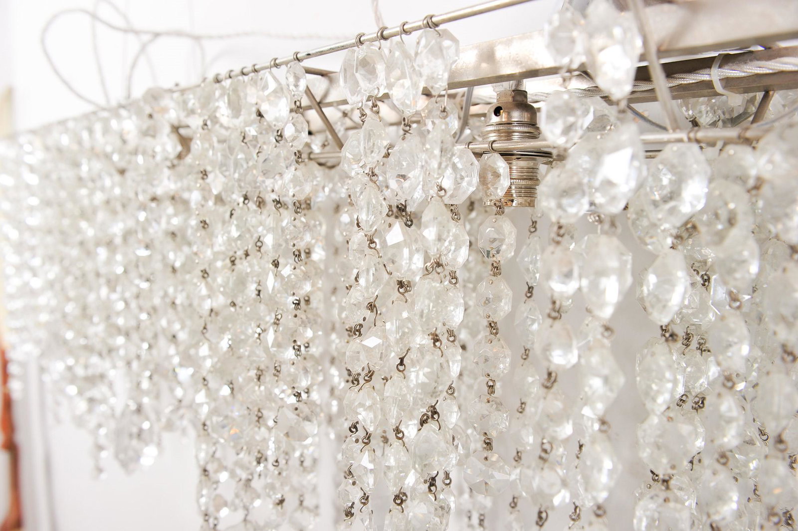 Suspension chandelier Italy, second half of the 20th century: 161 x 18 x 42 cm in metal and crystal, with teardrop pendants and faceted rounds in counterpart. Manufacture Lolli - Memmoli.