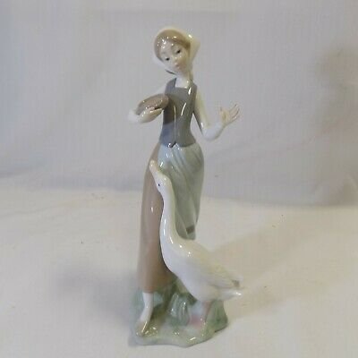 Lladro Girl feeding Goose #1052: UP FOR SALE IS A VERY NICE VINTAGE LLADRO GIRL FIGURINE FEEDING A GOOSE # 1052 ACCORDING TO THE LLADRO CATALOG/BOOK.SHE WAS ISSUED IN 1969. SHE IS IN EXCELLENT CONDITION WITHOUT ANY ISSUES AND STANDS