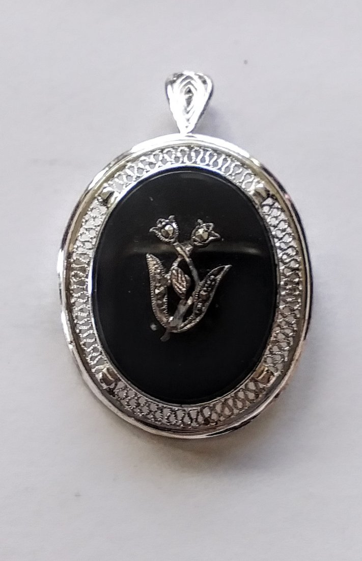 Sterling silver and Onyx brooch/ pendant: Sterling Silver and black onyx with small flower and marcasite accent. Marked Sterling Germany on the back