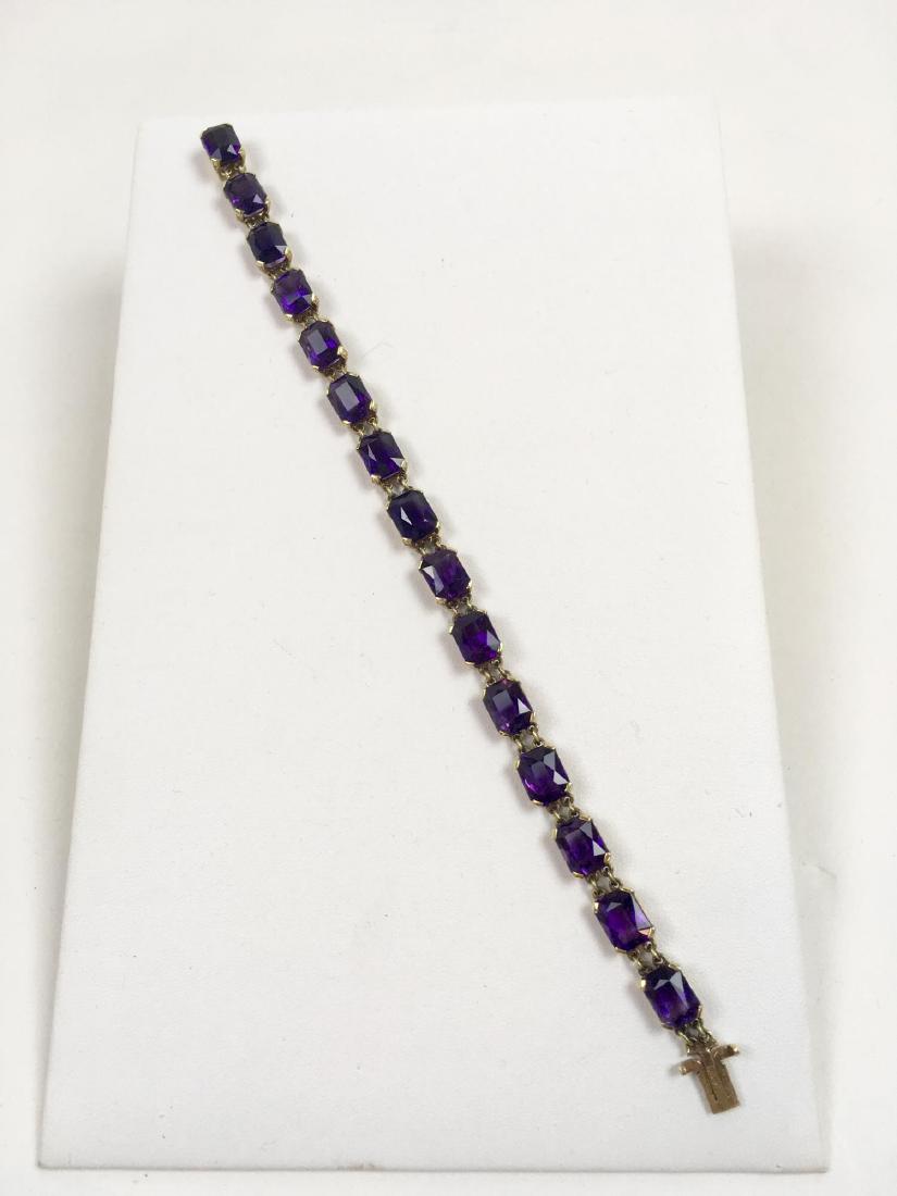 14K YELLOW GOLD AND AMETHYST BRACELET: Tennis style bracelet with 15 emerald cut amethyst stones approximately 9 mm x 7 mm each set in 14k yellow gold - 7.5 inches - weighs 17 g - very good condition with tight locking clasp