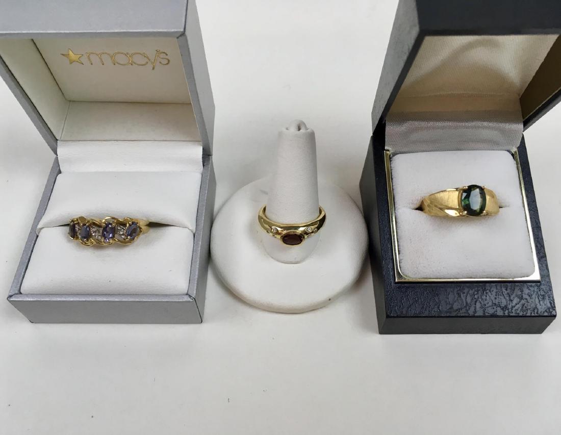 THREE 10K YELLOW GOLD RINGS: Three 10 karat yellow gold rings - rhodolite garnet size 8 3 g with six diamonds, tanzanite size 8 2 g and a green tourmaline size 7.75 3 g