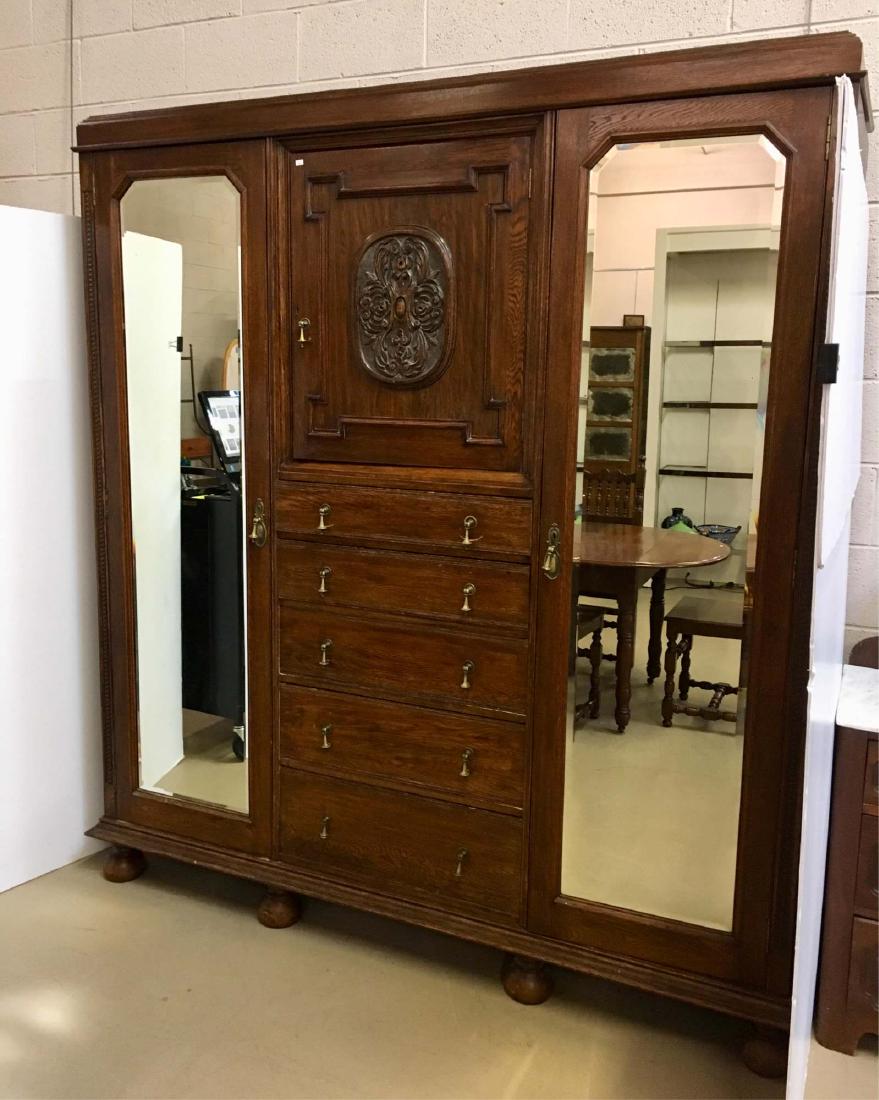 ANTIQUE ENGLISH OAK ARMOIRE: Two beveled mirrored door hanging clothes closets - top center cabinet with 2 shelf over 5 drawers - armoire breaks down into 5 pieces - 75" x 23.75" x 80.5" - shipping will be costly due to size / we
