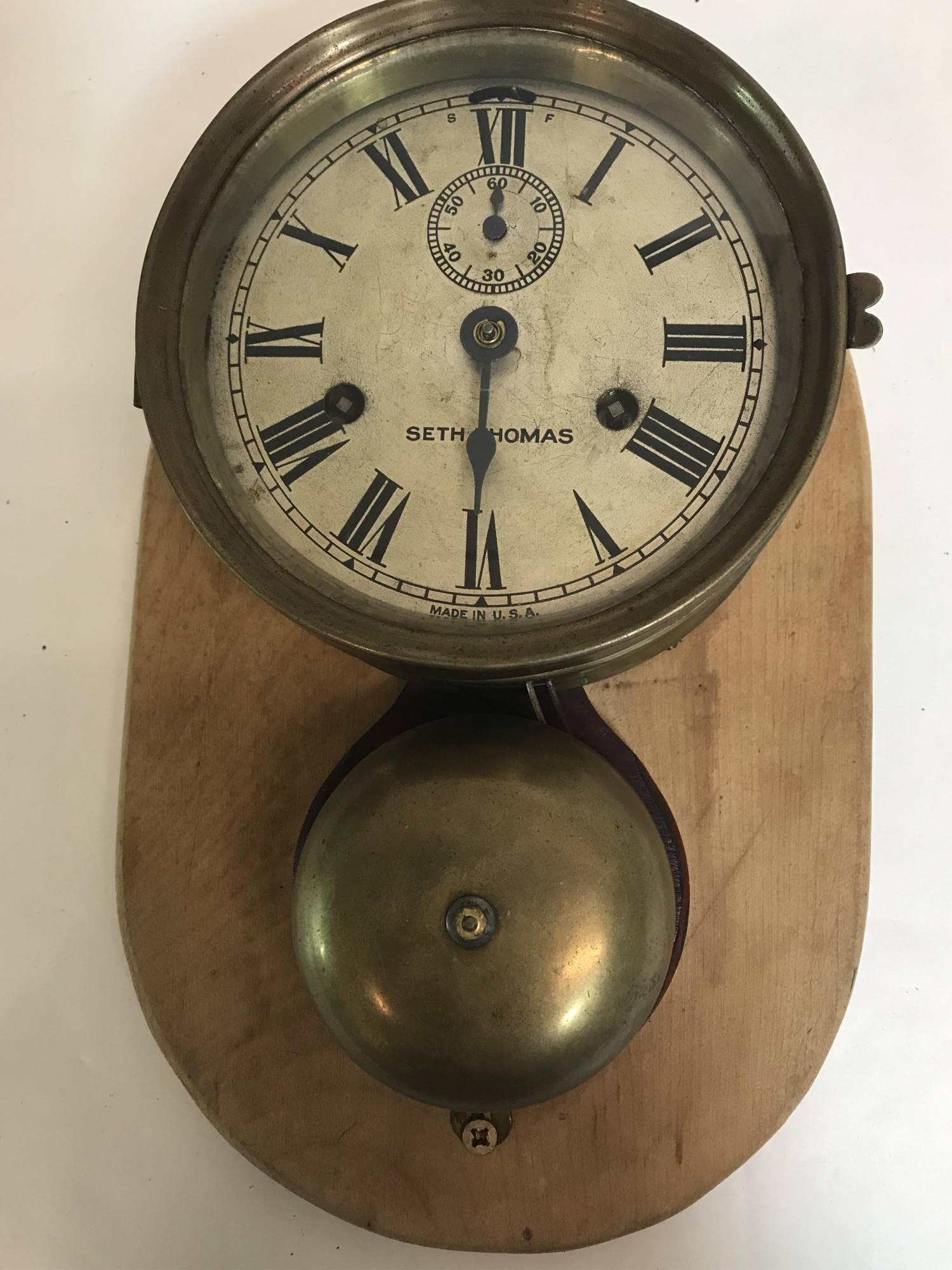 SETH THOMAS MOUNTED BELL SHIPS CLOCK: Made in USA , broken minute hand, key included, 8.75" x 13.5 "x 4.25" diameter, is working but strike wind is not working