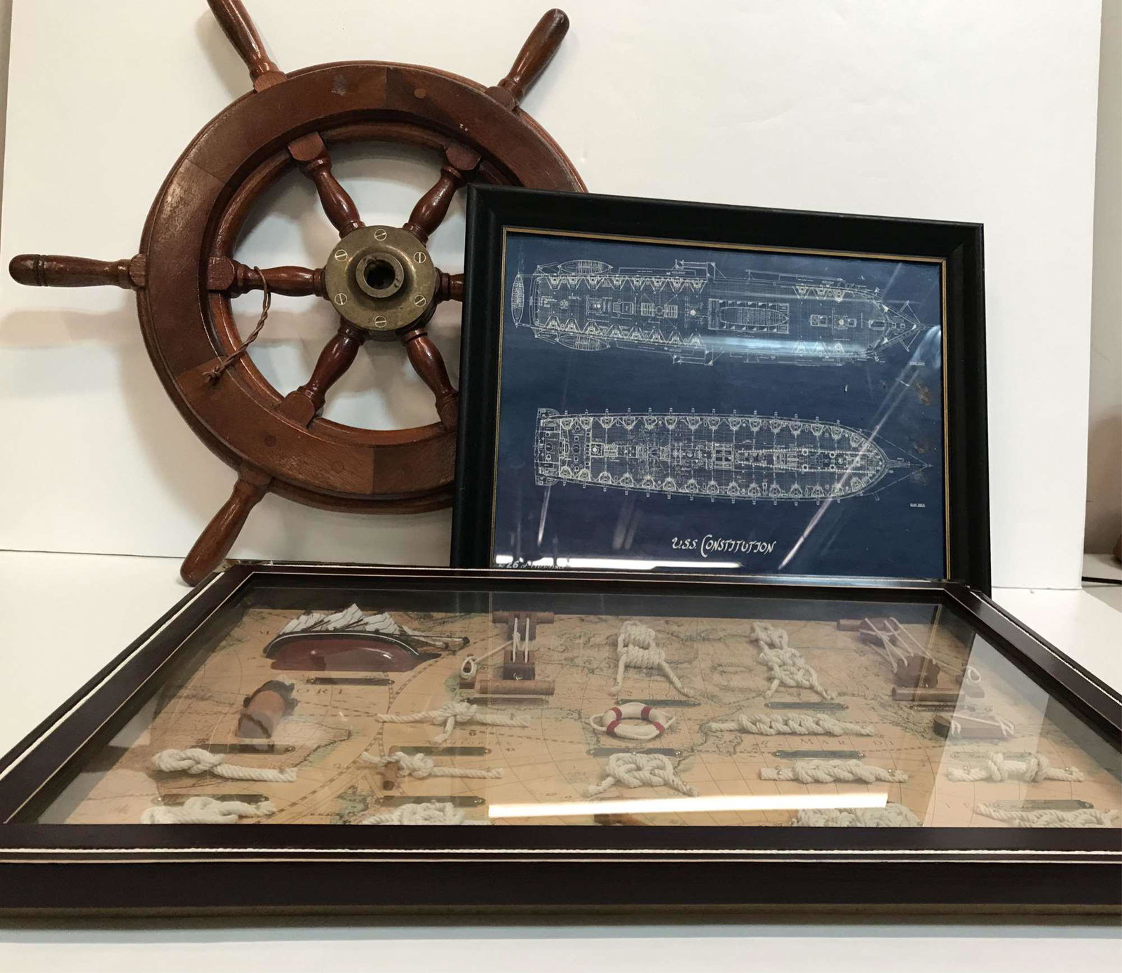 NAUTICAL FRAMED WORK AND SHIPS WHEEL: Framed example of ship supplies and knots measures 21.5” x 15.25” , USS Constitution print 26 of 550 - has some debris under glass and measures 15.5” x 11.5” framed, Ships whee